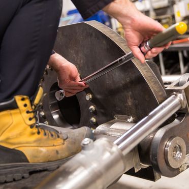 A person wearing yellow boots is working on a machine