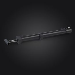 Un cylindre hydraulique noir est posé sur une surface noire.