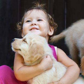 Puppy Shots — Child Hugging a Puppy in Brenham, TX