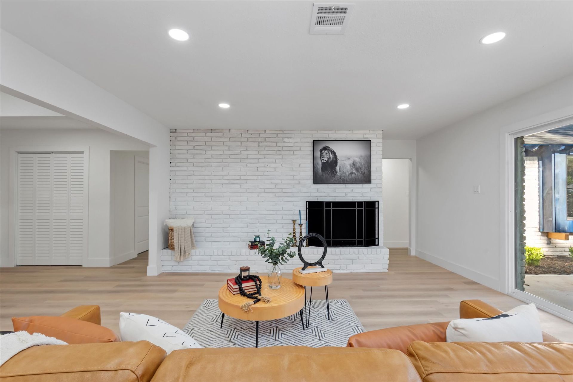 A living room with a couch , table , television and fireplace.