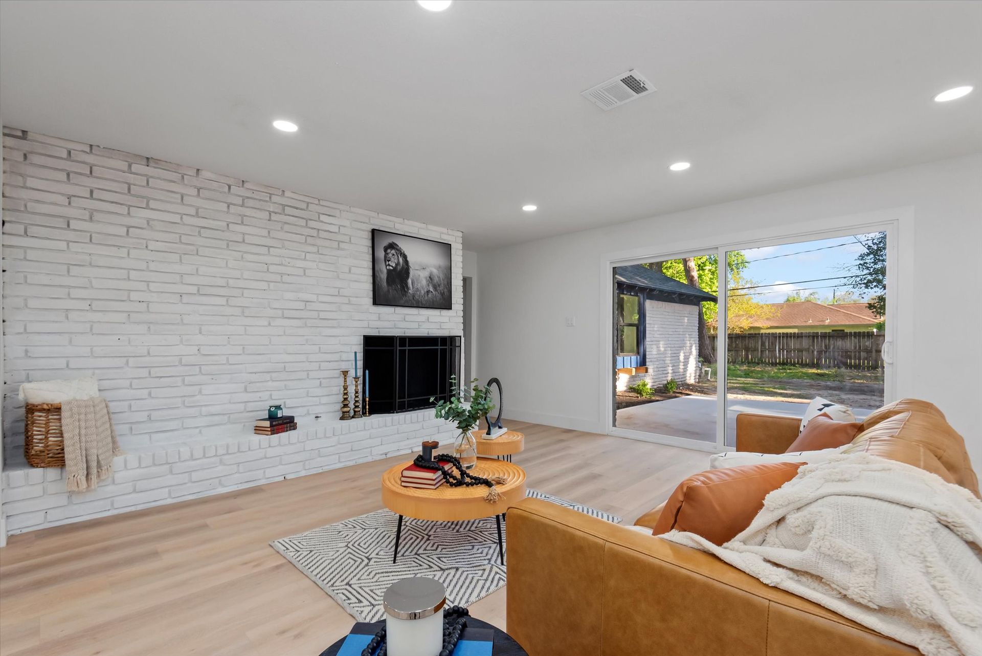 A living room with a couch , table , fireplace and sliding glass doors.