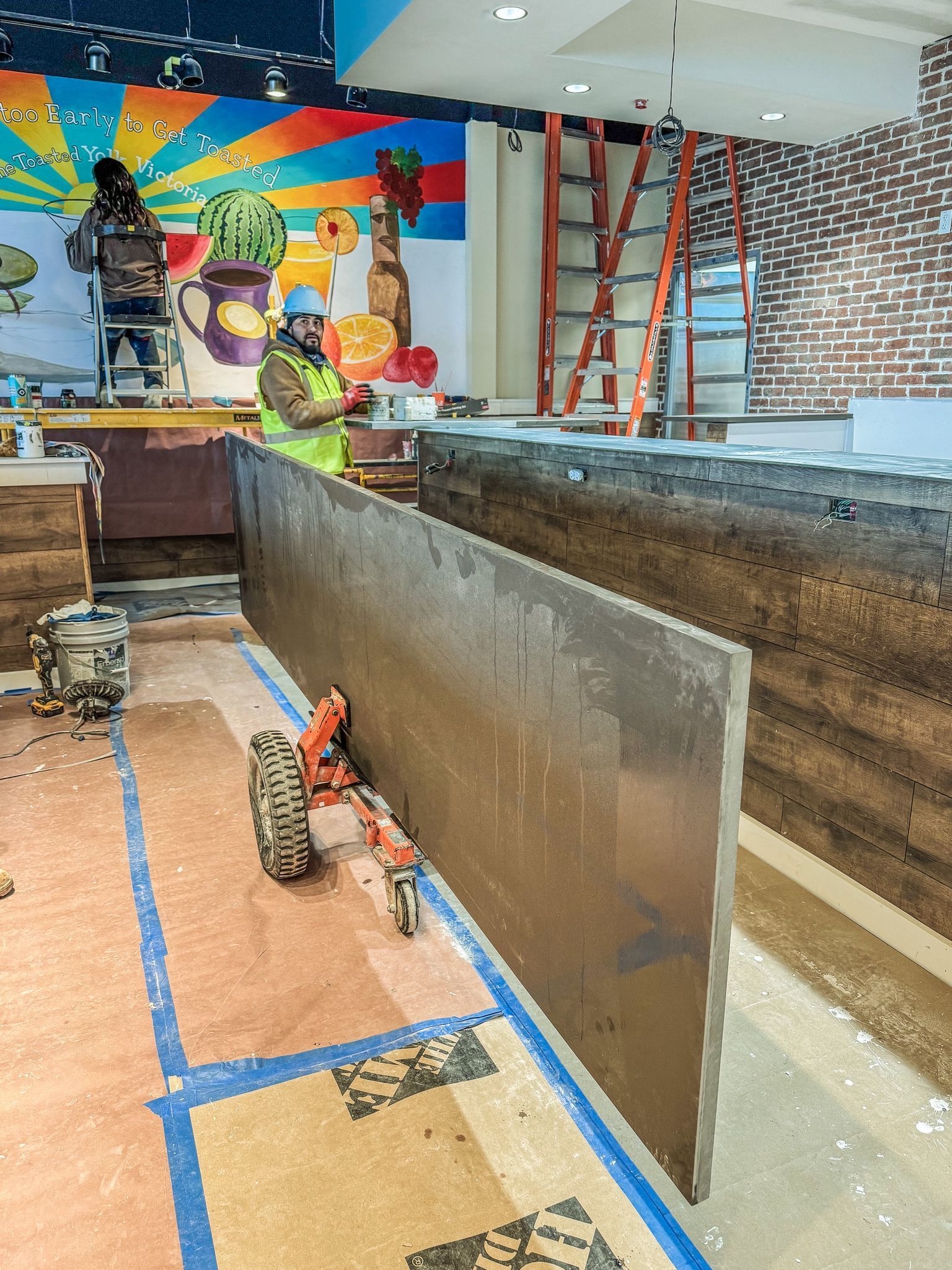 A man is working on a large piece of metal in a room.