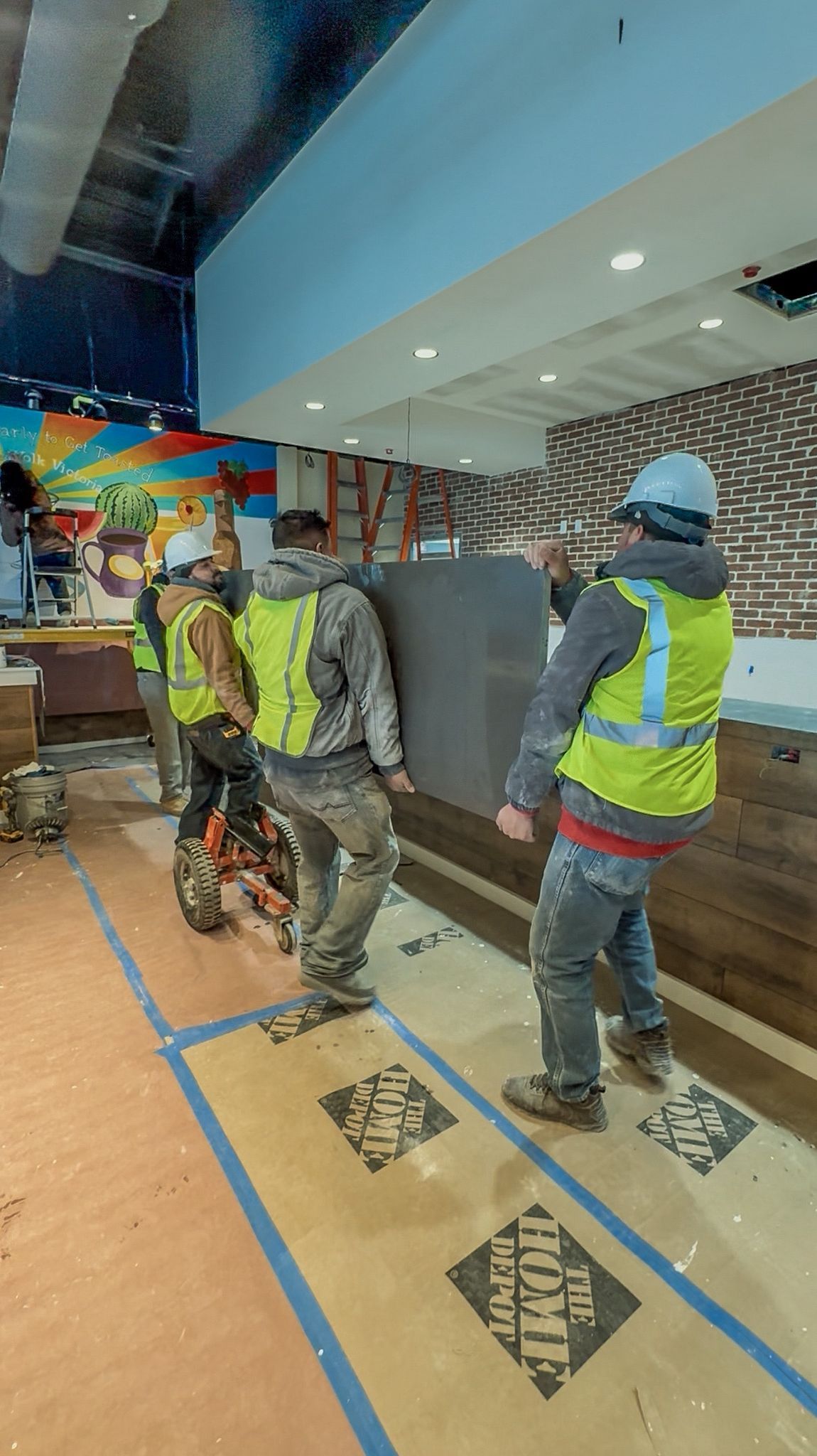 A group of construction workers are carrying a large piece of wood.