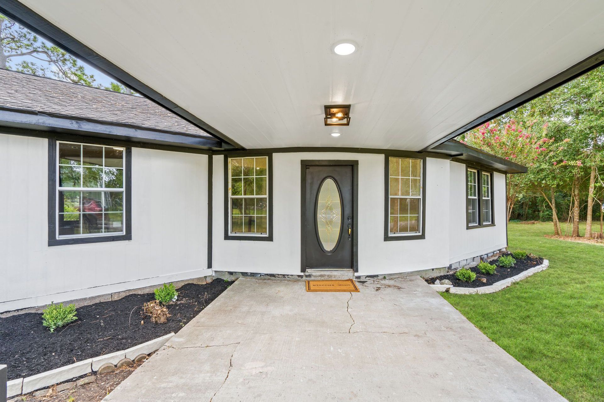 A white house with a black door and a covered porch.