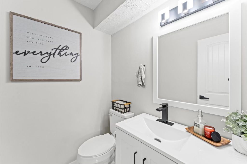 A bathroom with a sink , toilet and mirror.
