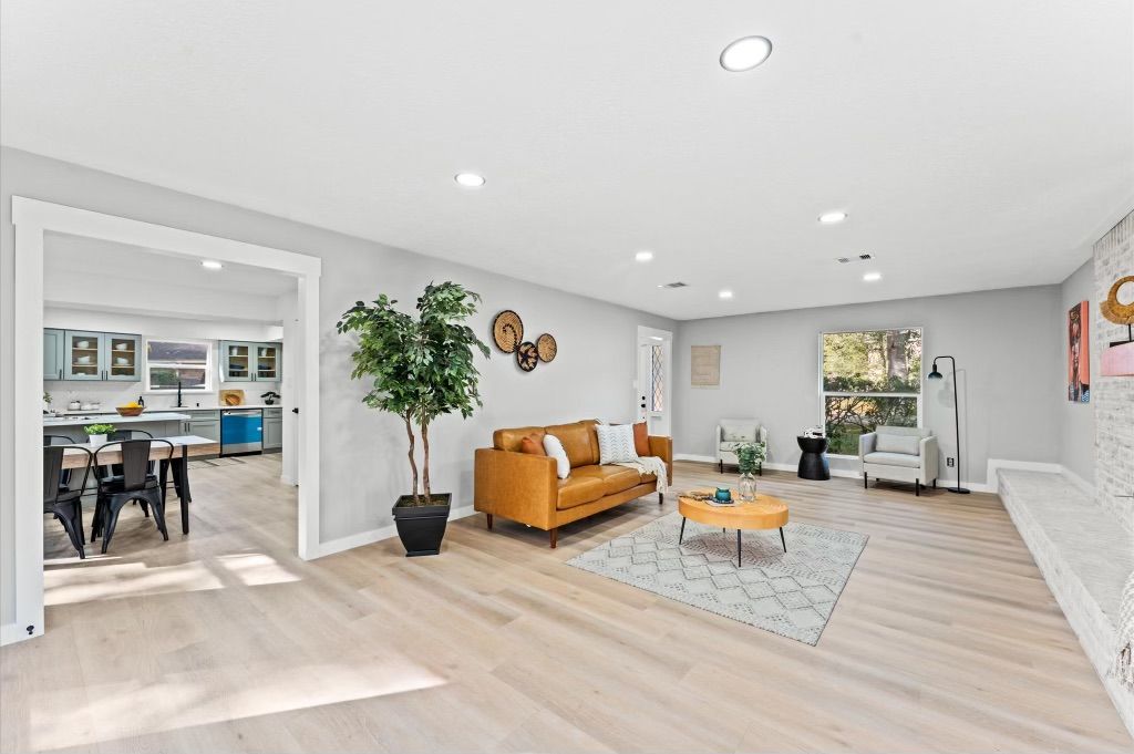 A living room with a couch , coffee table , and potted plant.