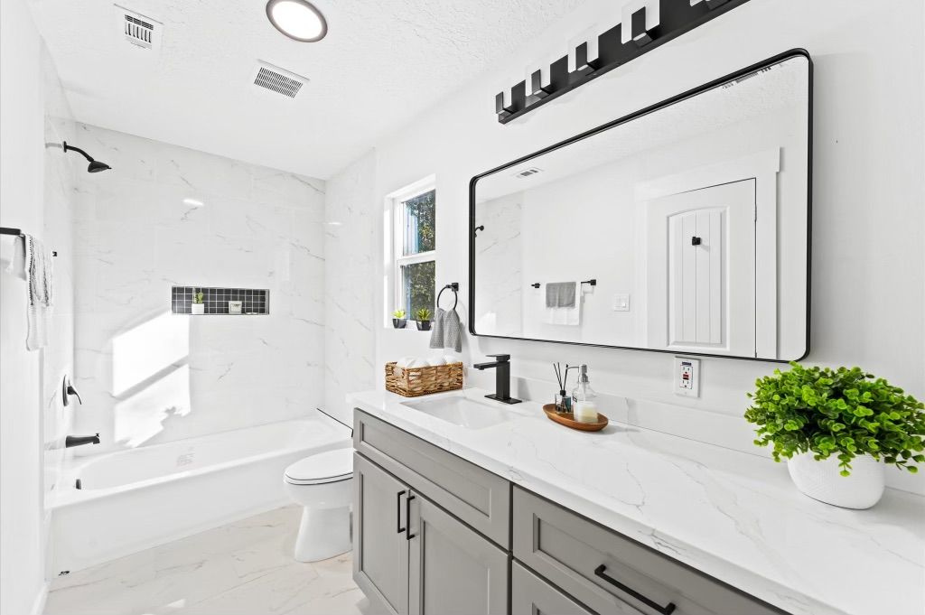 A bathroom with a sink , toilet , and mirror.