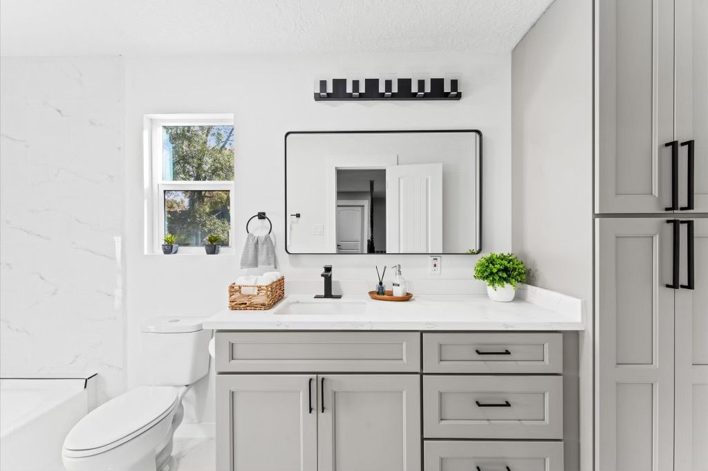 A bathroom with a sink , toilet , and mirror.