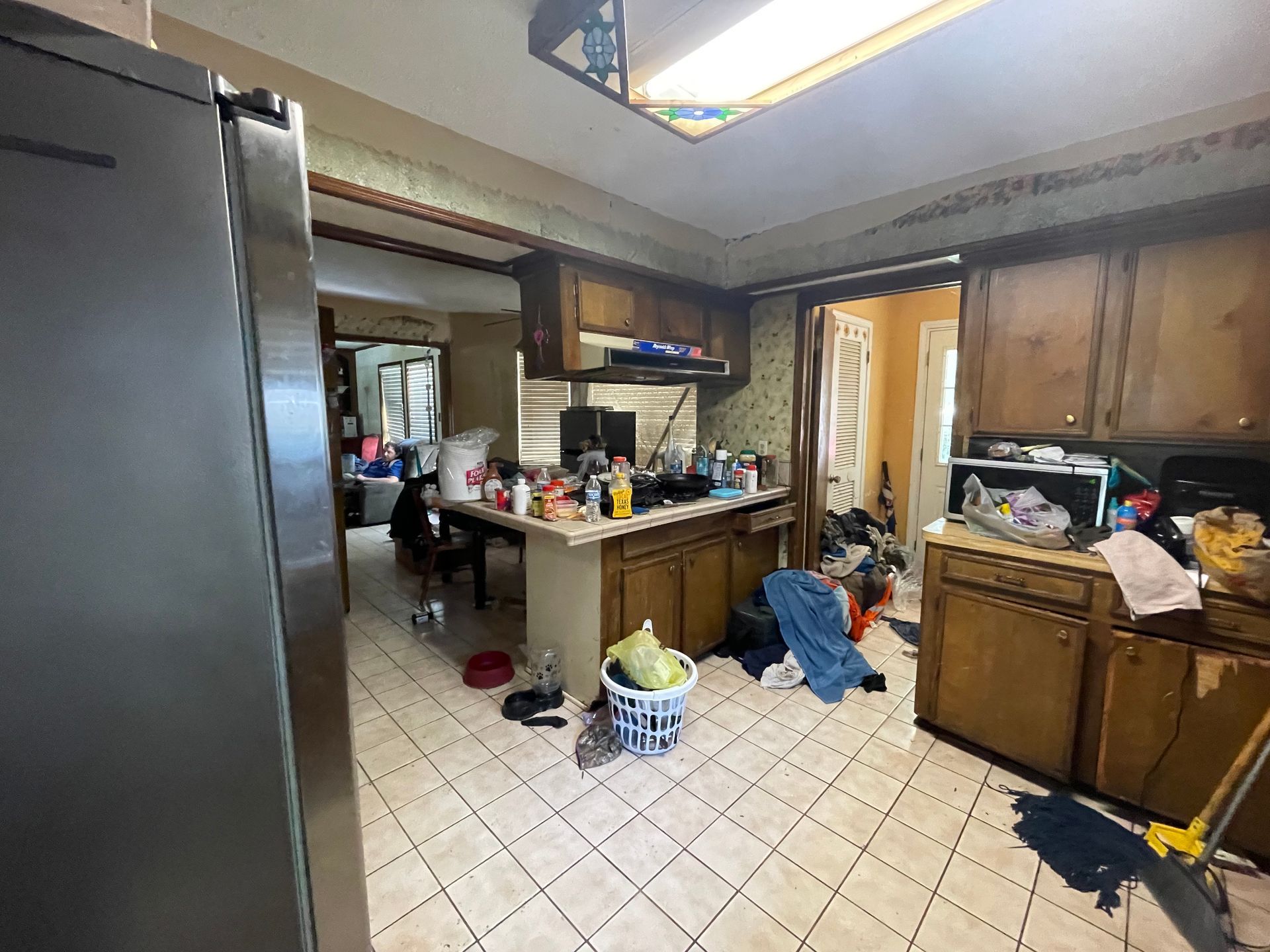 A kitchen with a stainless steel refrigerator and wooden cabinets.
