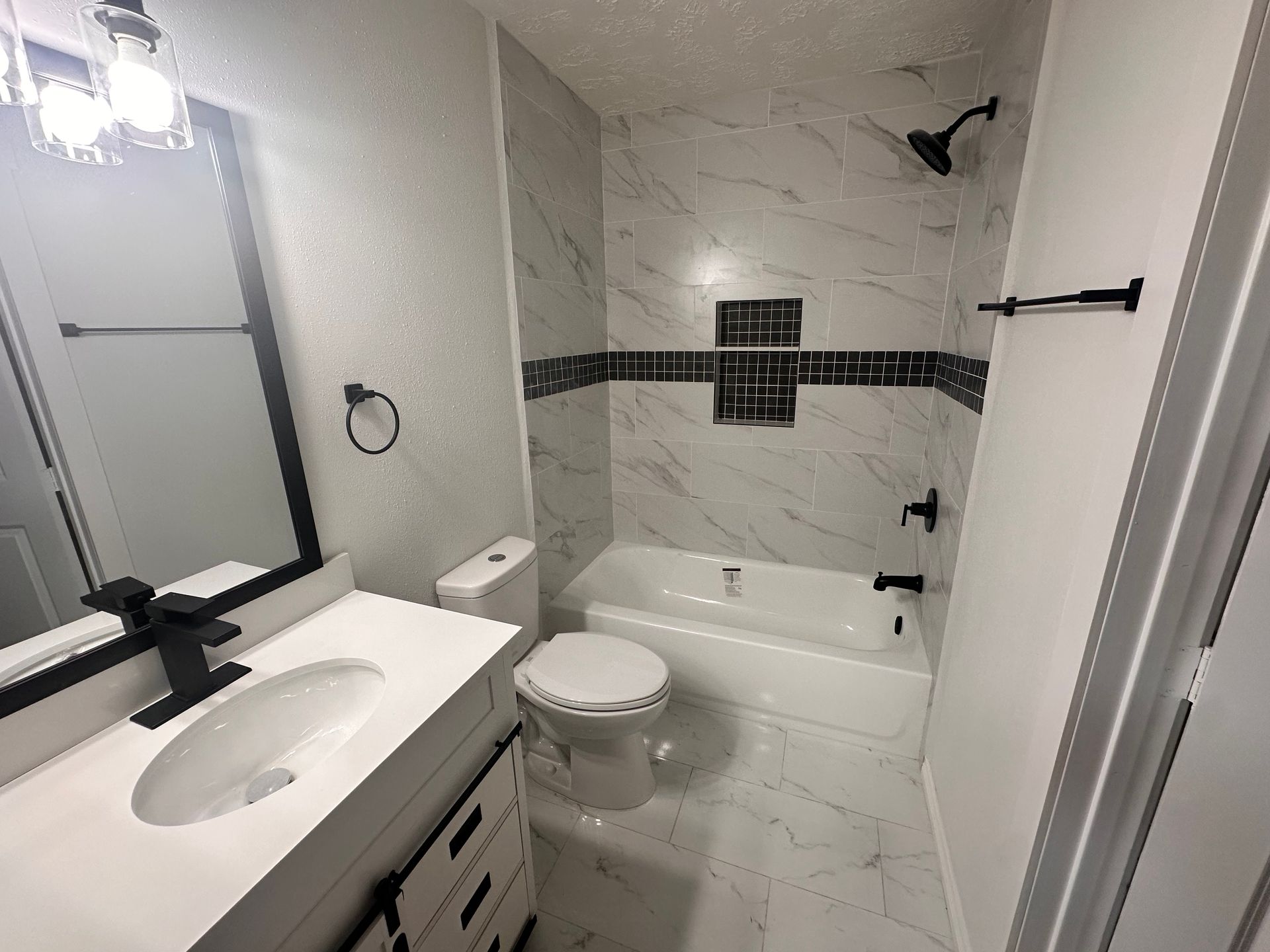 A bathroom with a sink , toilet , bathtub and mirror.