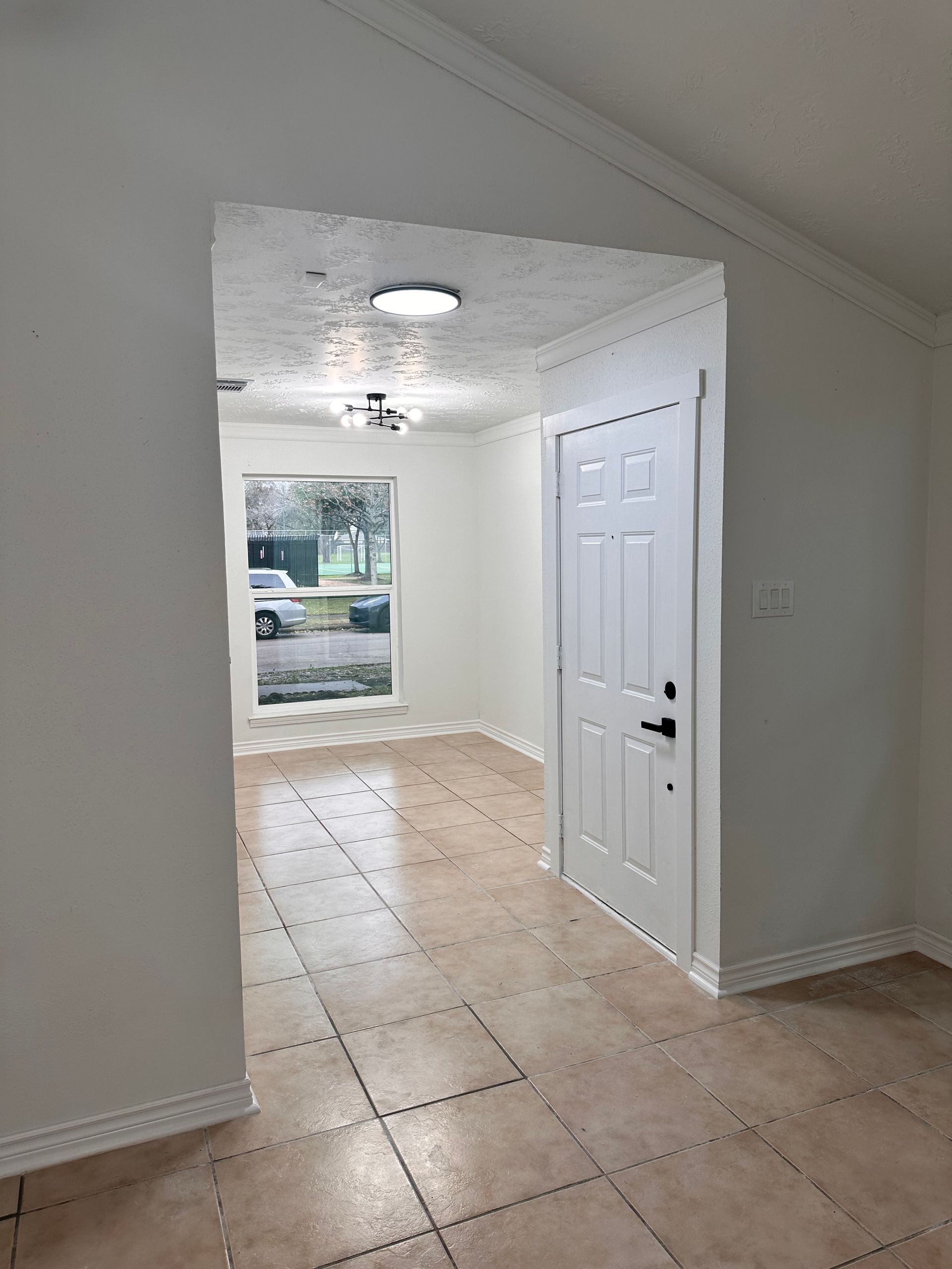 An empty room with a door and a window.