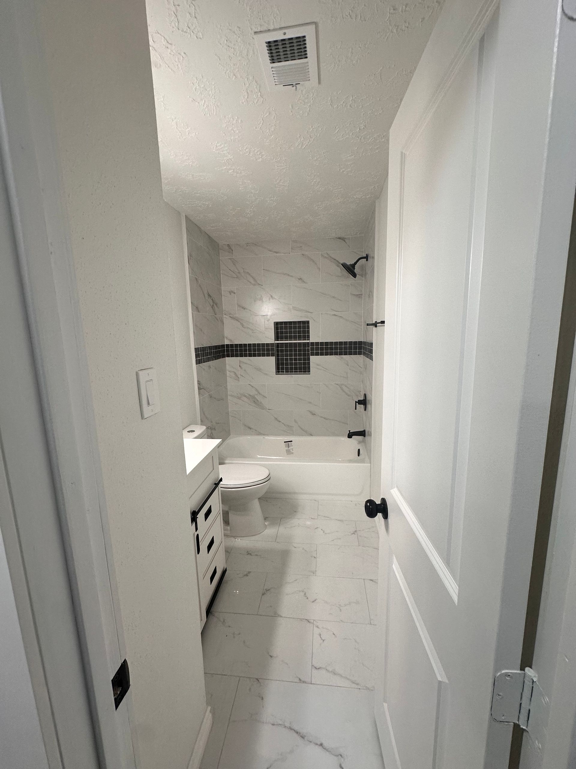 A bathroom with a toilet , sink , tub and shower.