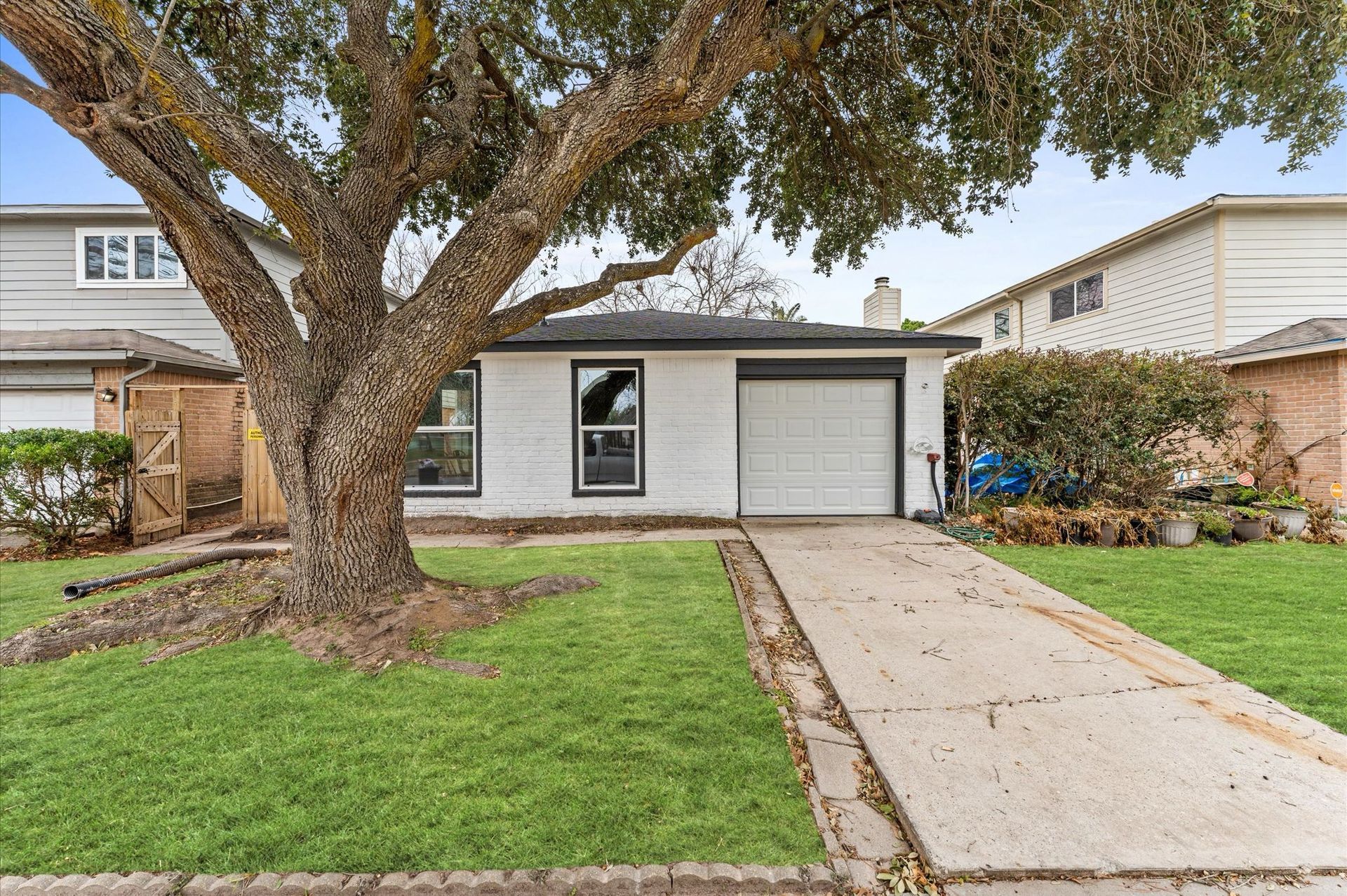 A white house with a tree in front of it