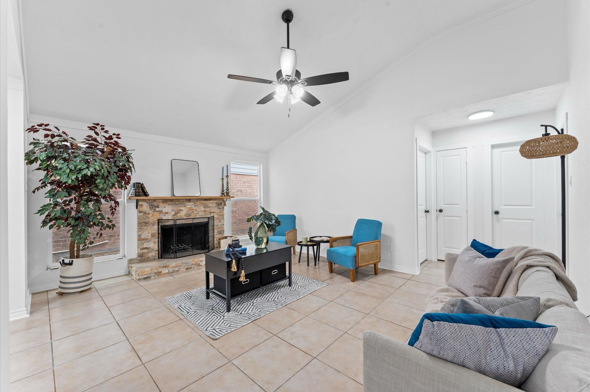 A living room with a couch , chairs , coffee table and fireplace.