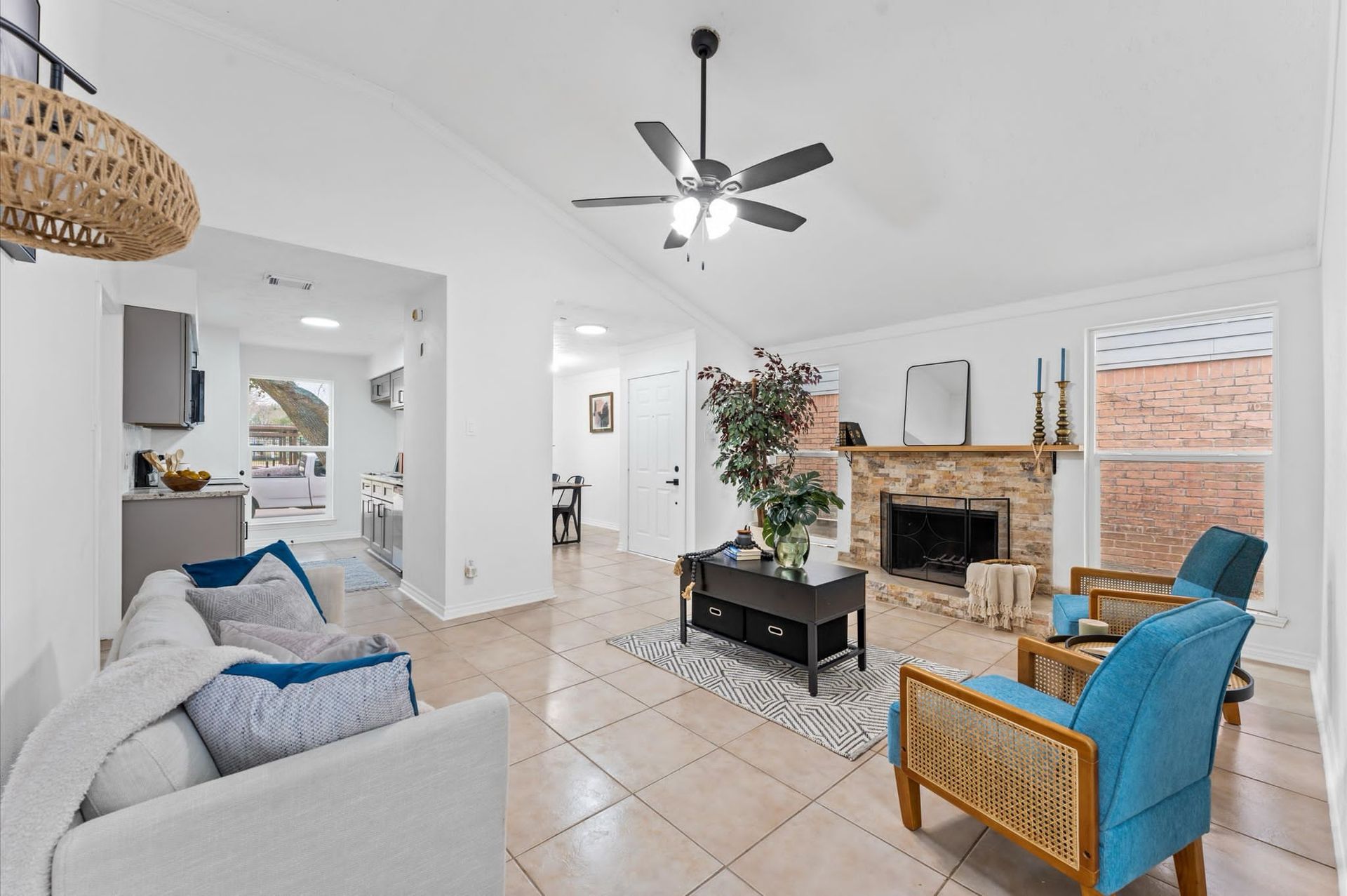 A living room with a ceiling fan and a fireplace.