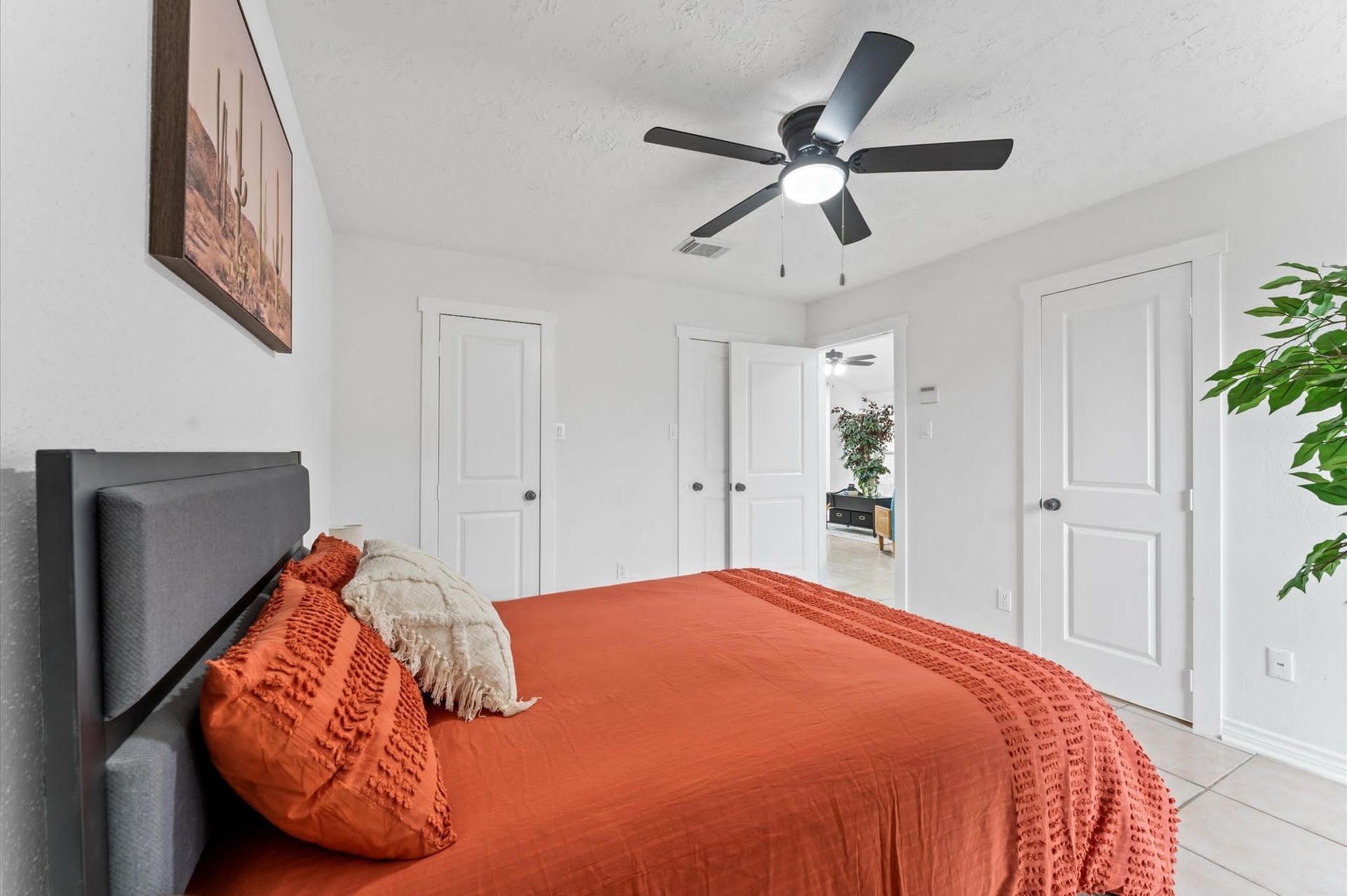 A bedroom with a bed and a ceiling fan.