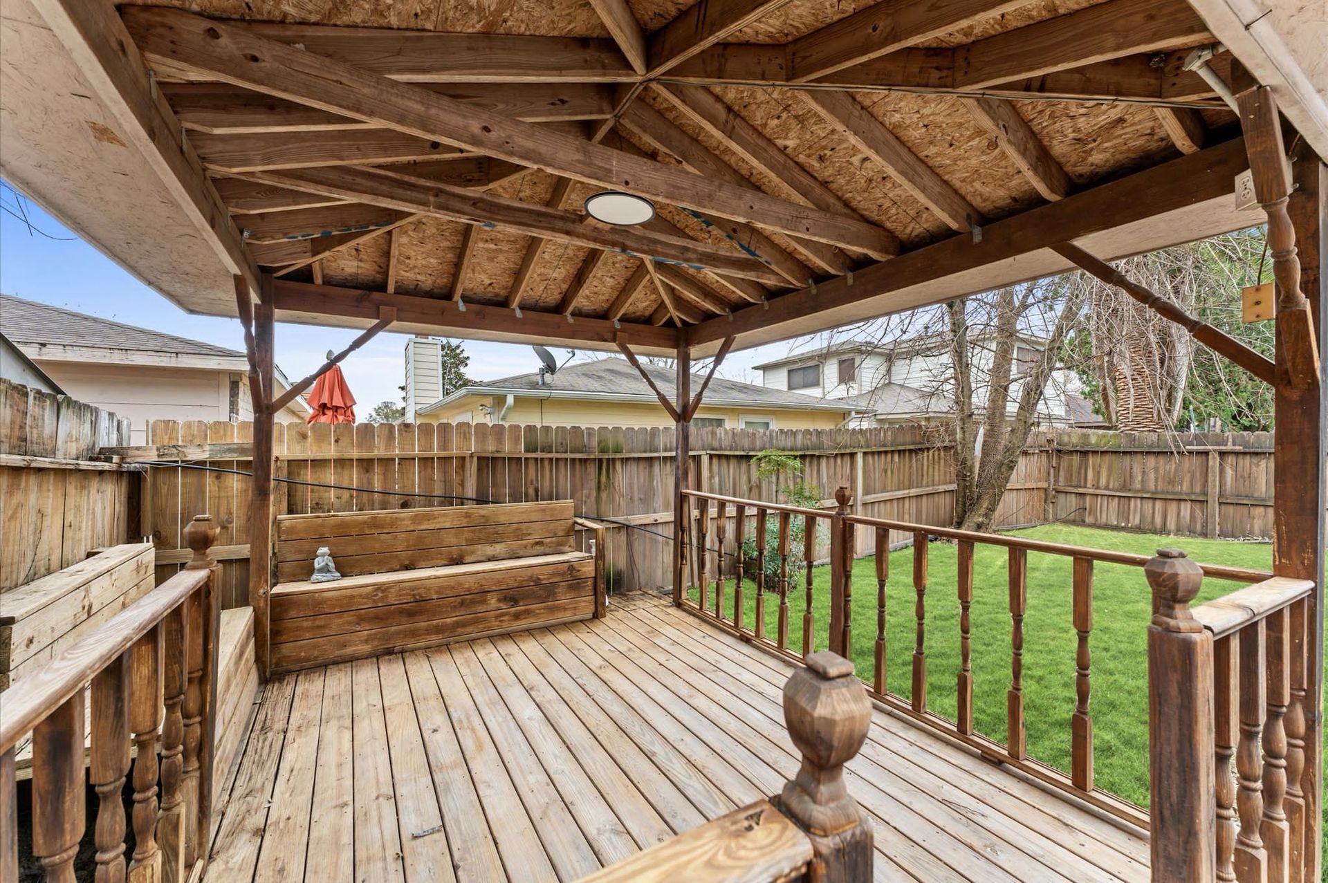 A wooden deck with a gazebo in the backyard.