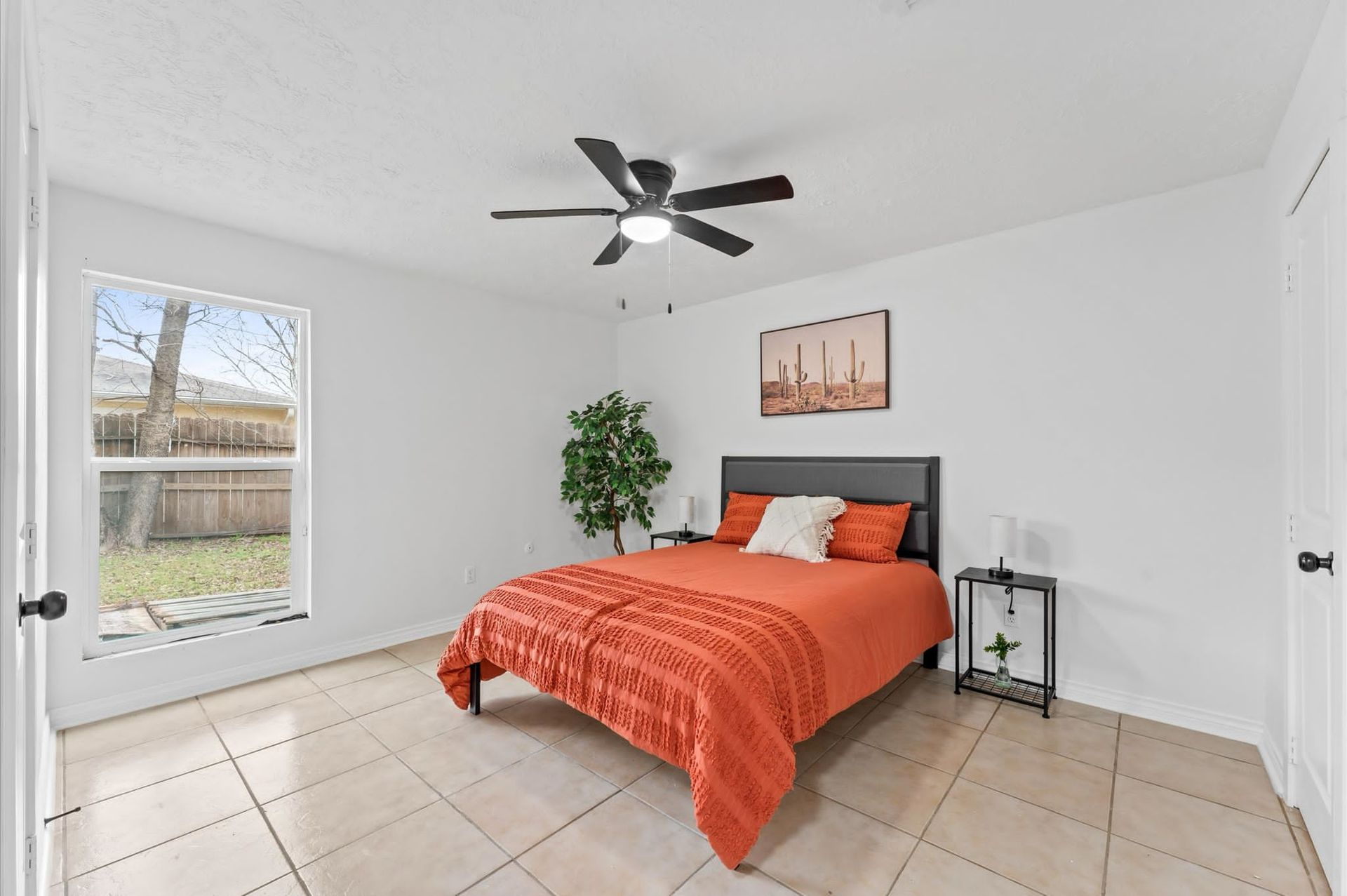 A bedroom with a bed and a ceiling fan.