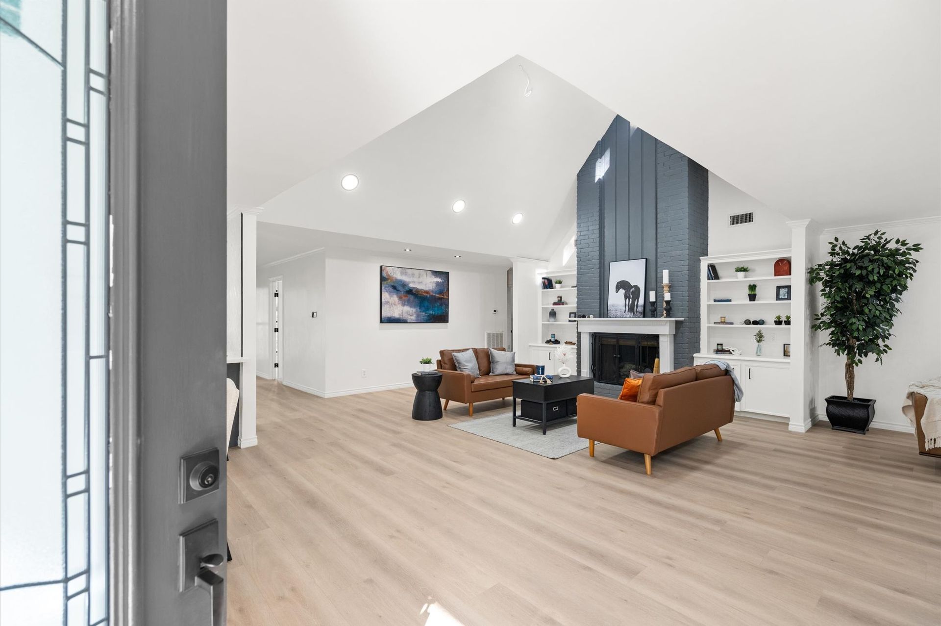 A living room with hardwood floors and a fireplace.