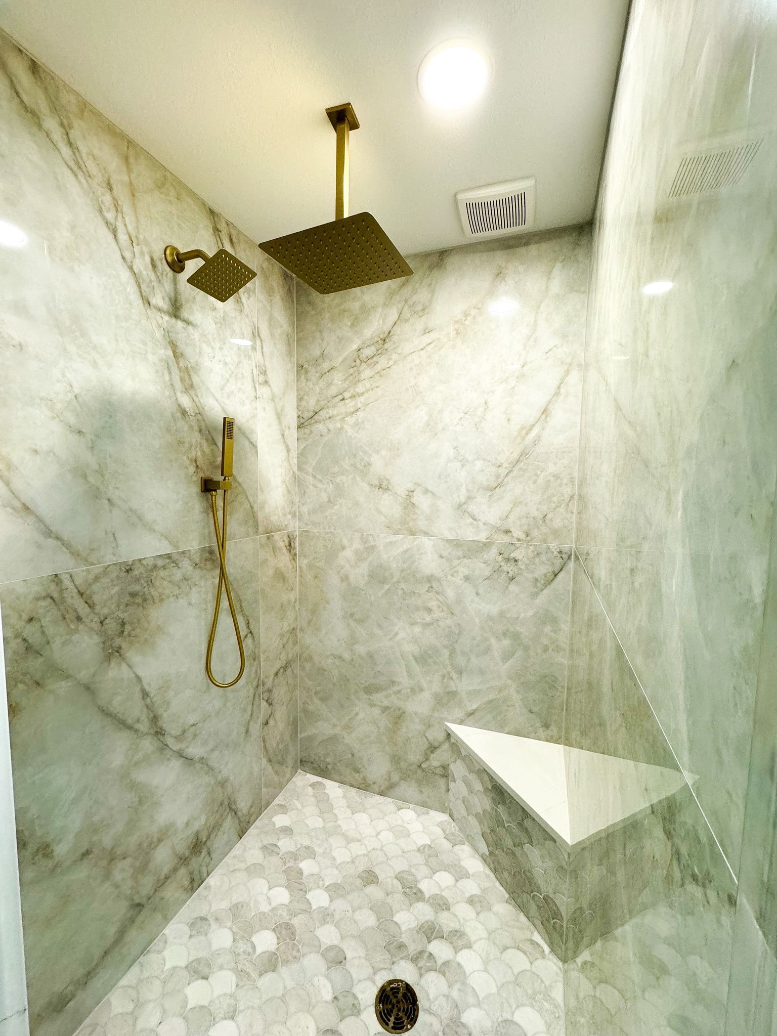 A shower with a ceiling fan and a shower head.