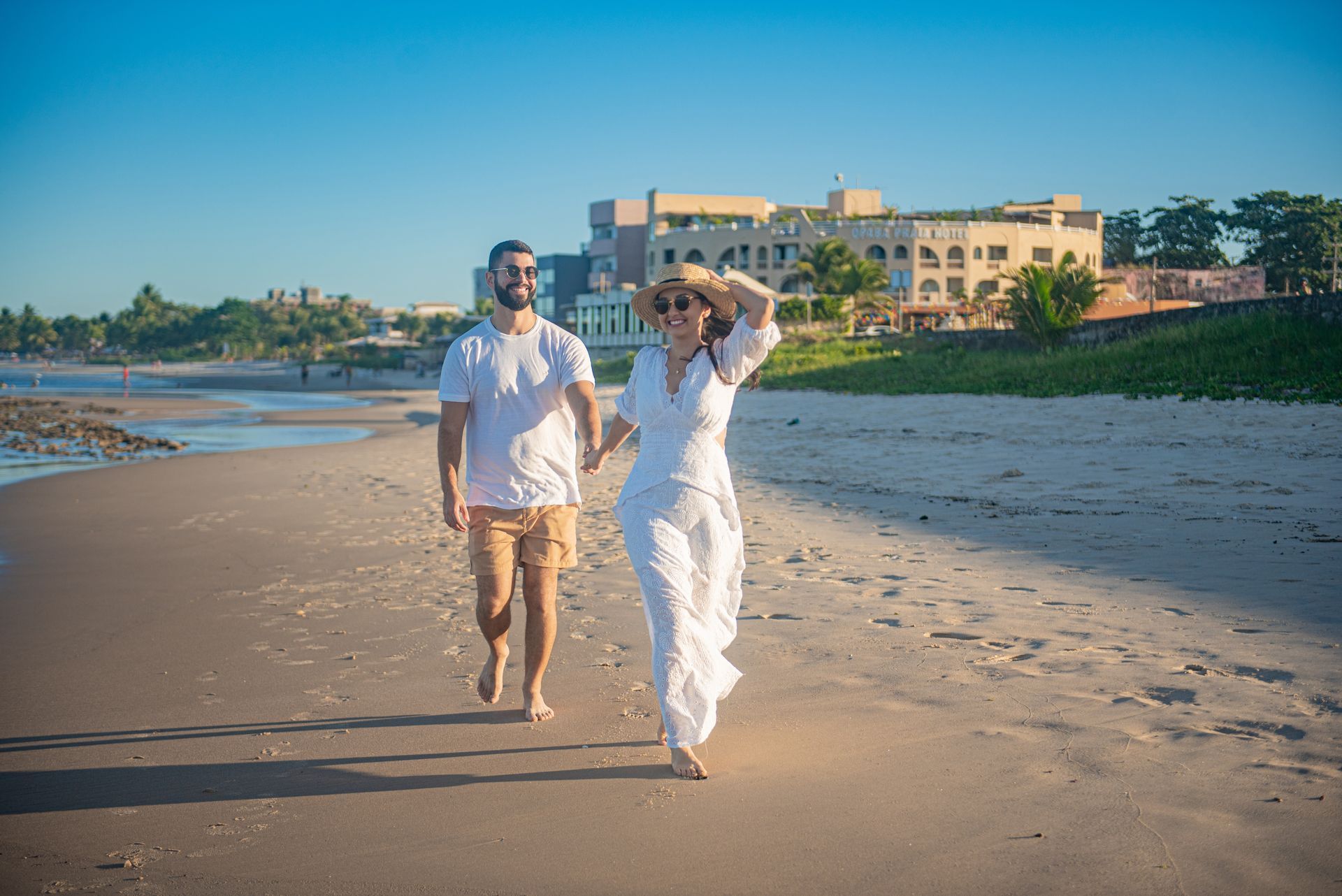 Um homem e uma mulher estão sentados na água na praia.