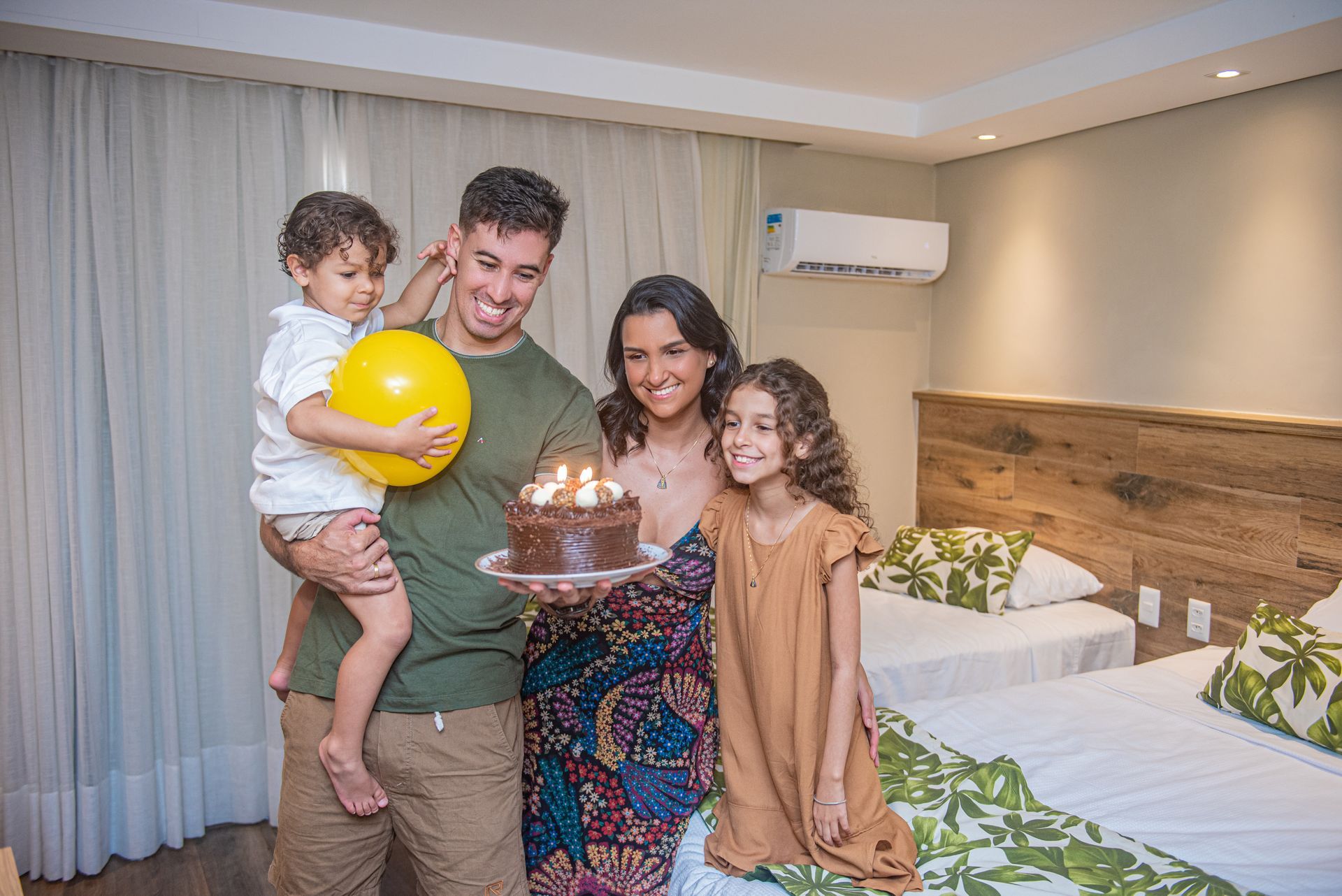 Uma família está comemorando o aniversário de uma criança com balões e confetes.