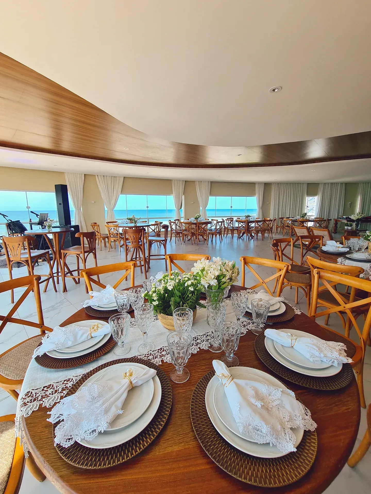 Uma mesa com pratos e guardanapos em um restaurante com vista para o mar.