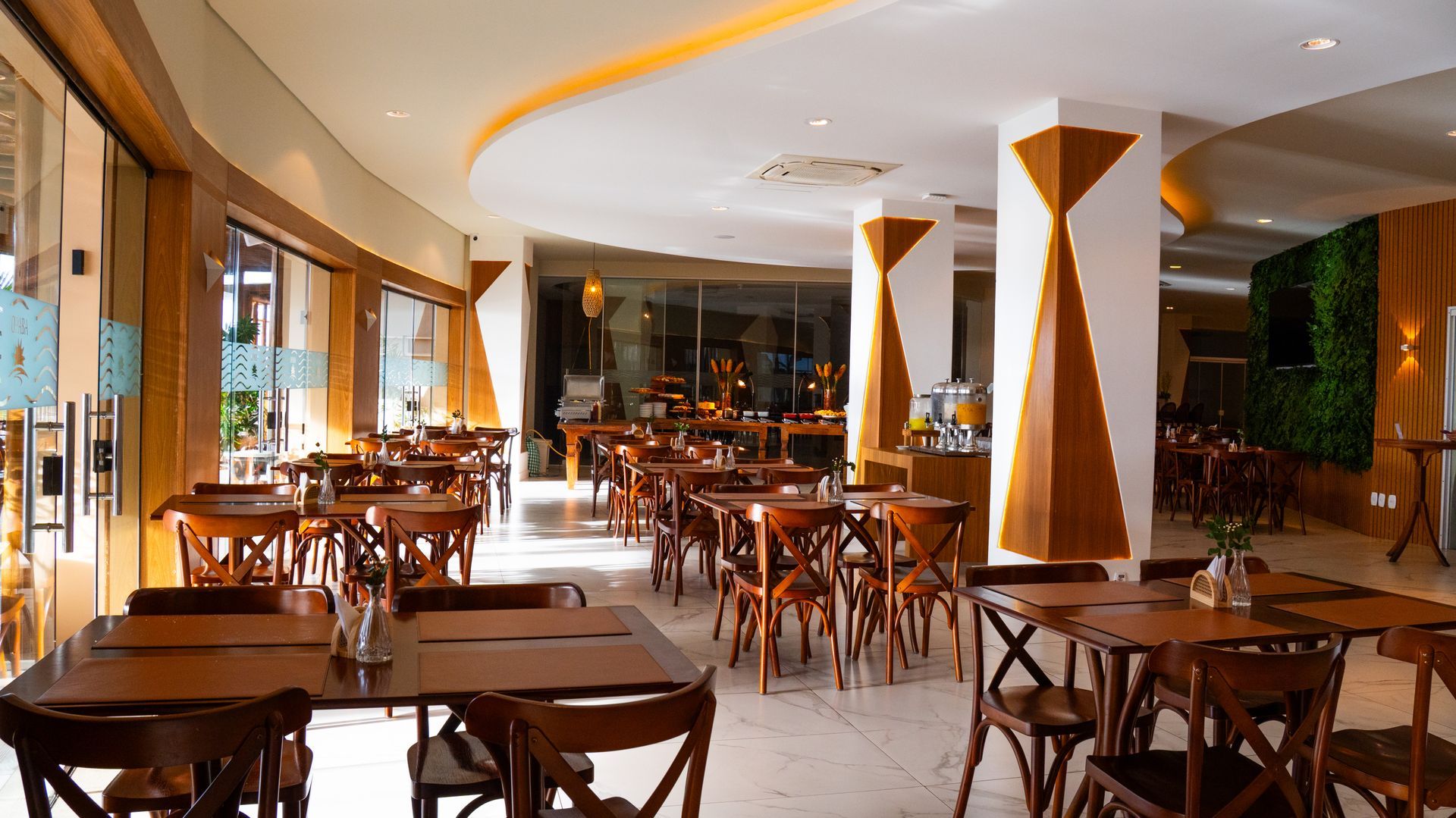 Um homem está servindo comida para uma mulher e um homem em um restaurante.