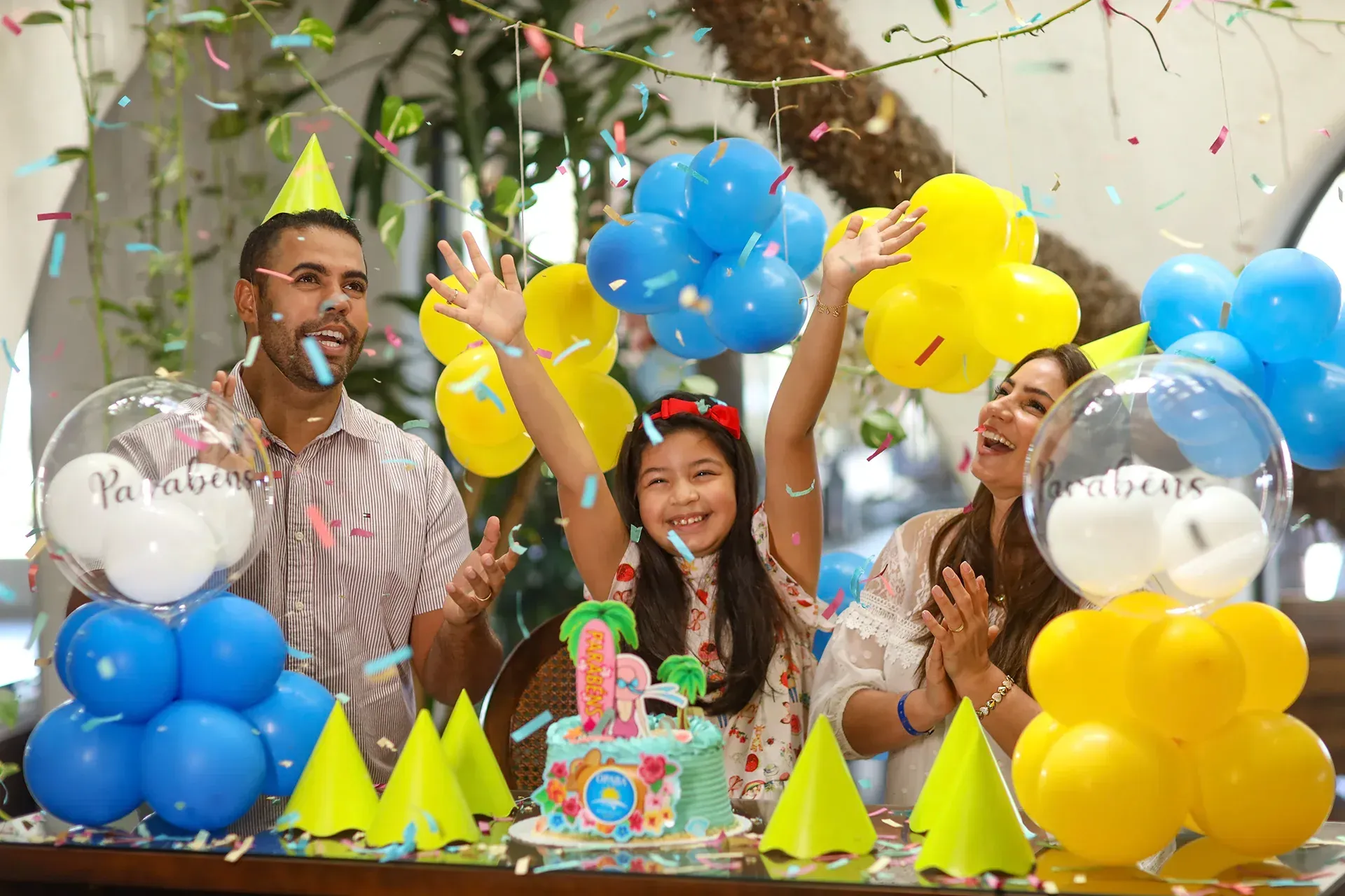 Uma família está comemorando o aniversário de uma criança com balões e confetes.