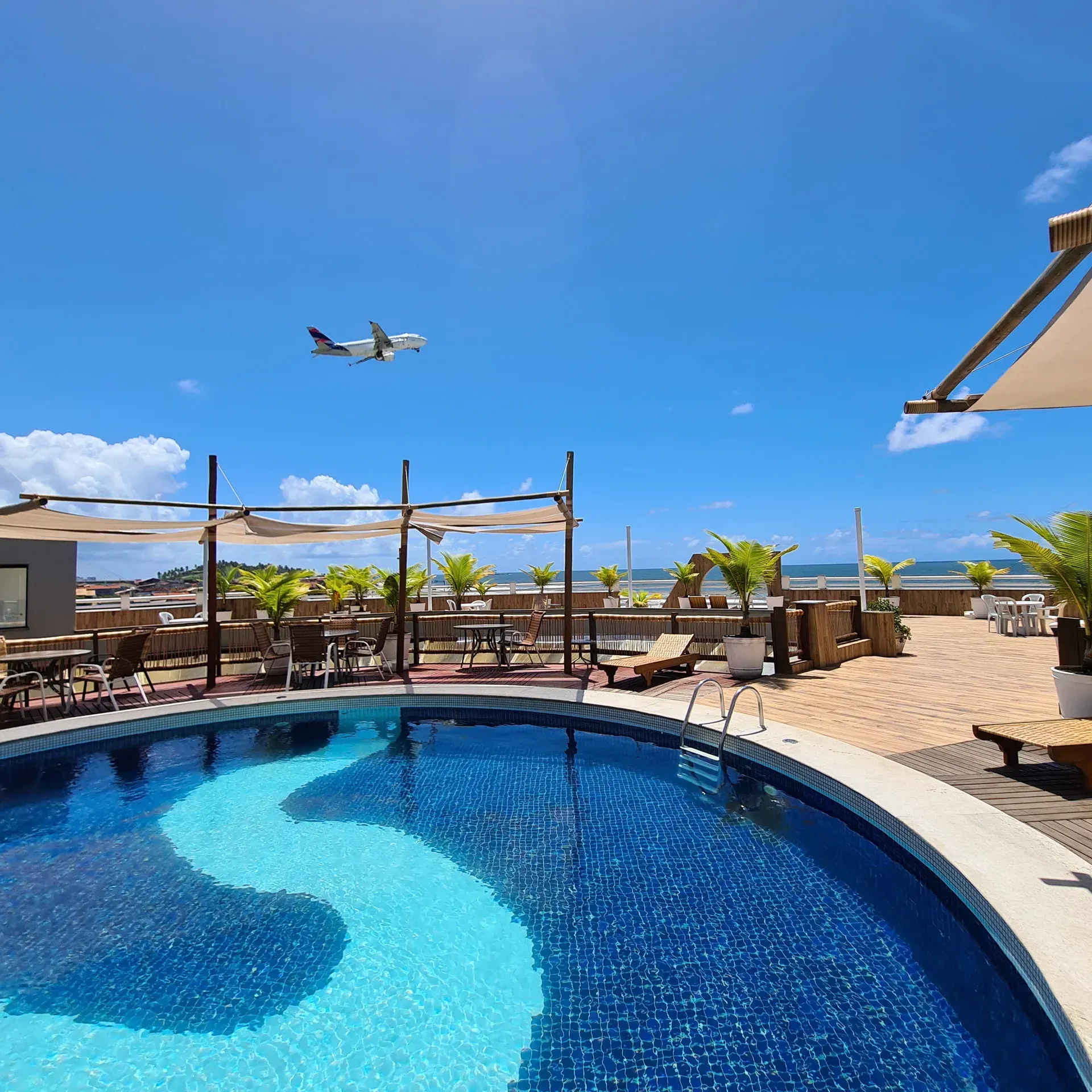 Uma grande piscina com um avião voando acima