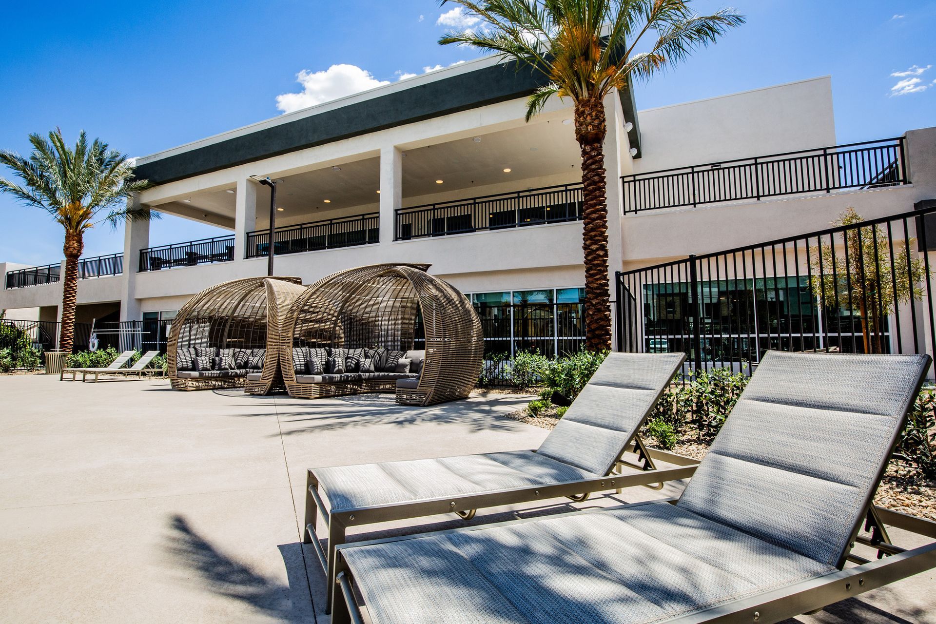 There are a lot of lounge chairs in front of a building.