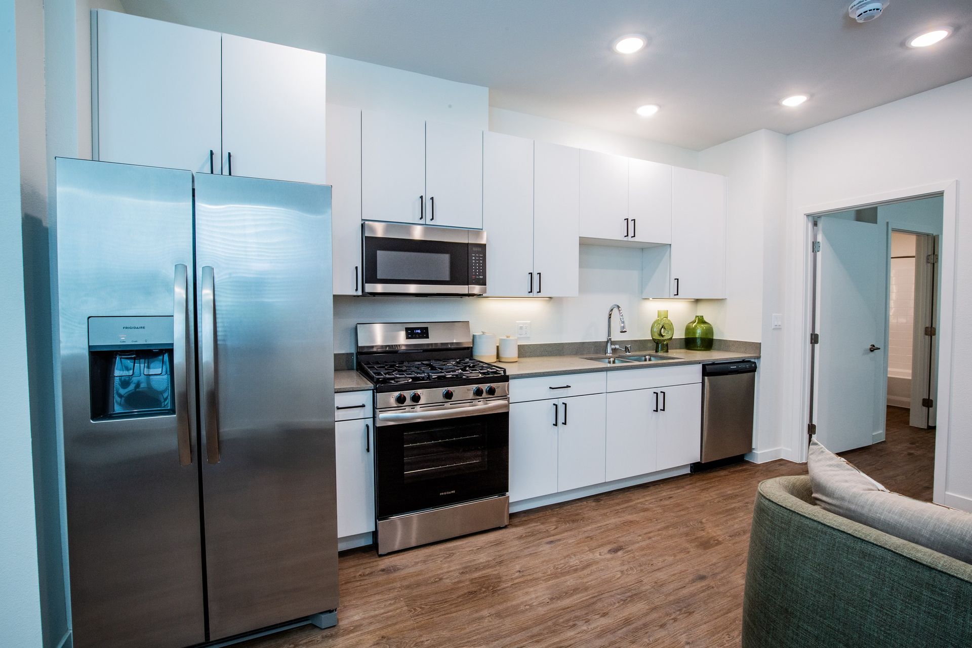 A kitchen with stainless steel appliances and white cabinets.