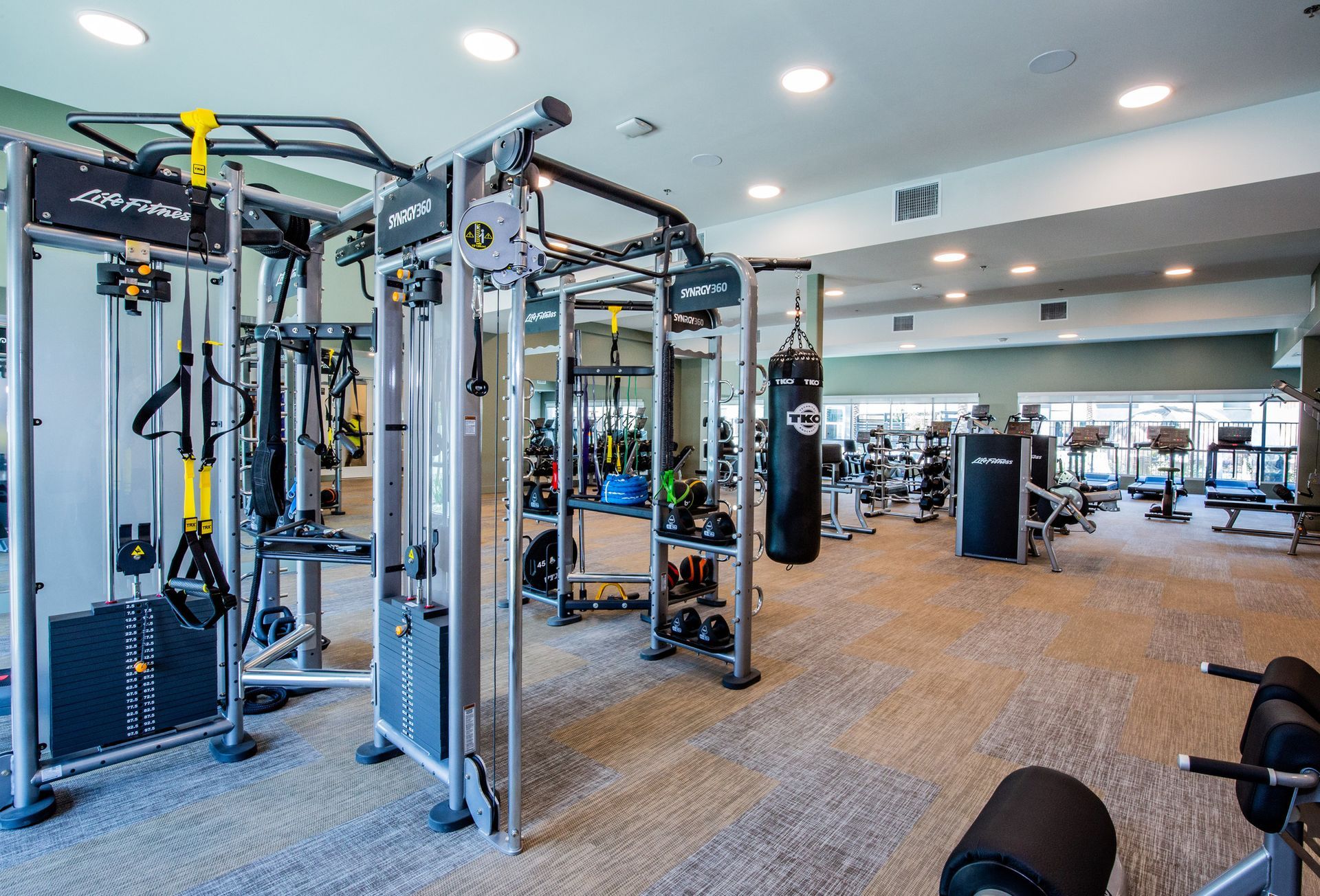 A large gym filled with lots of exercise equipment.