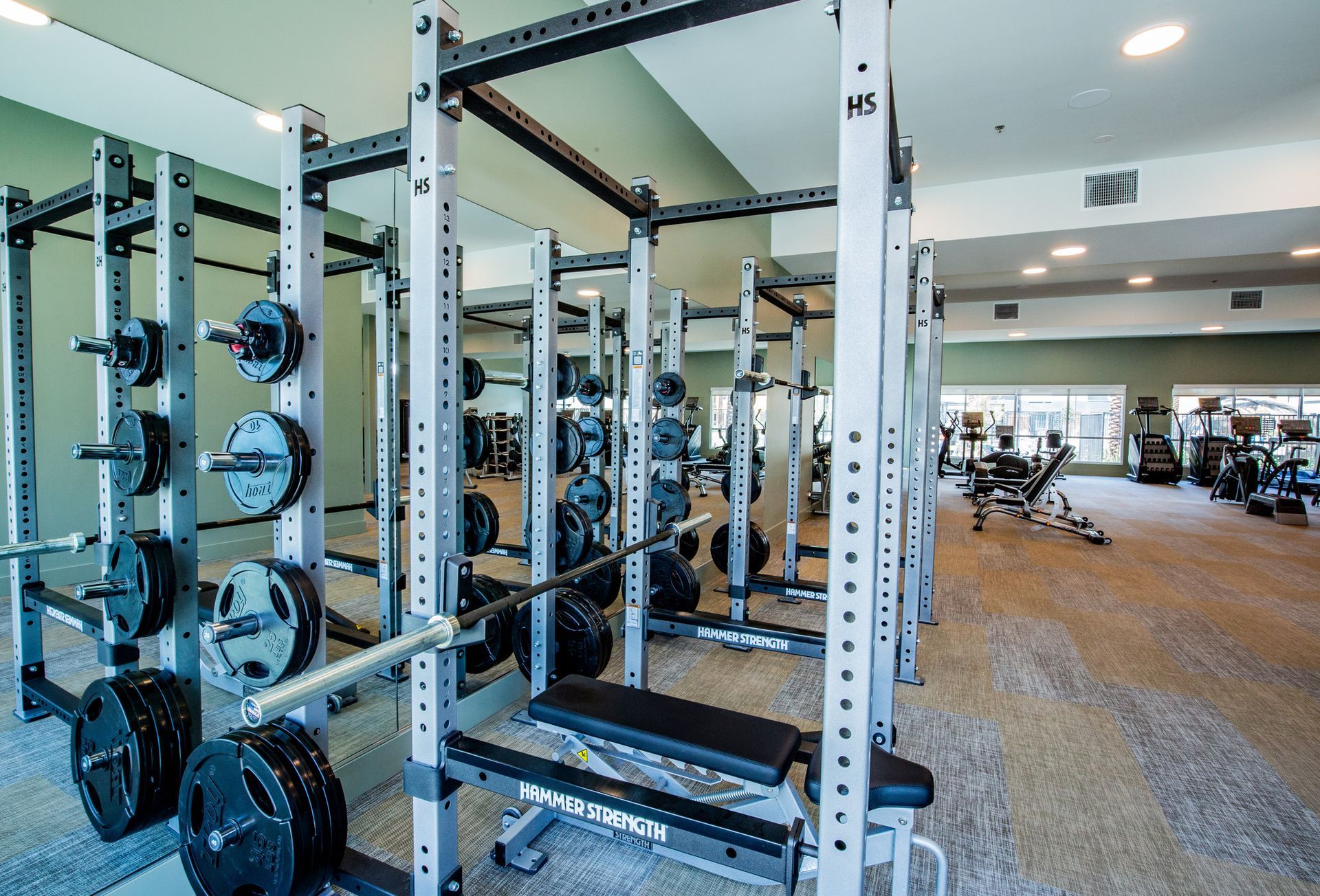 A gym filled with lots of exercise equipment and a bench.