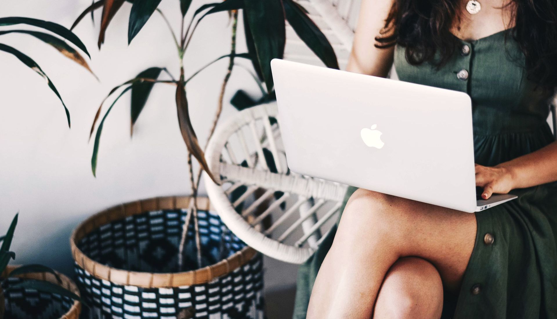 A woman is sitting in a chair using a laptop computer.