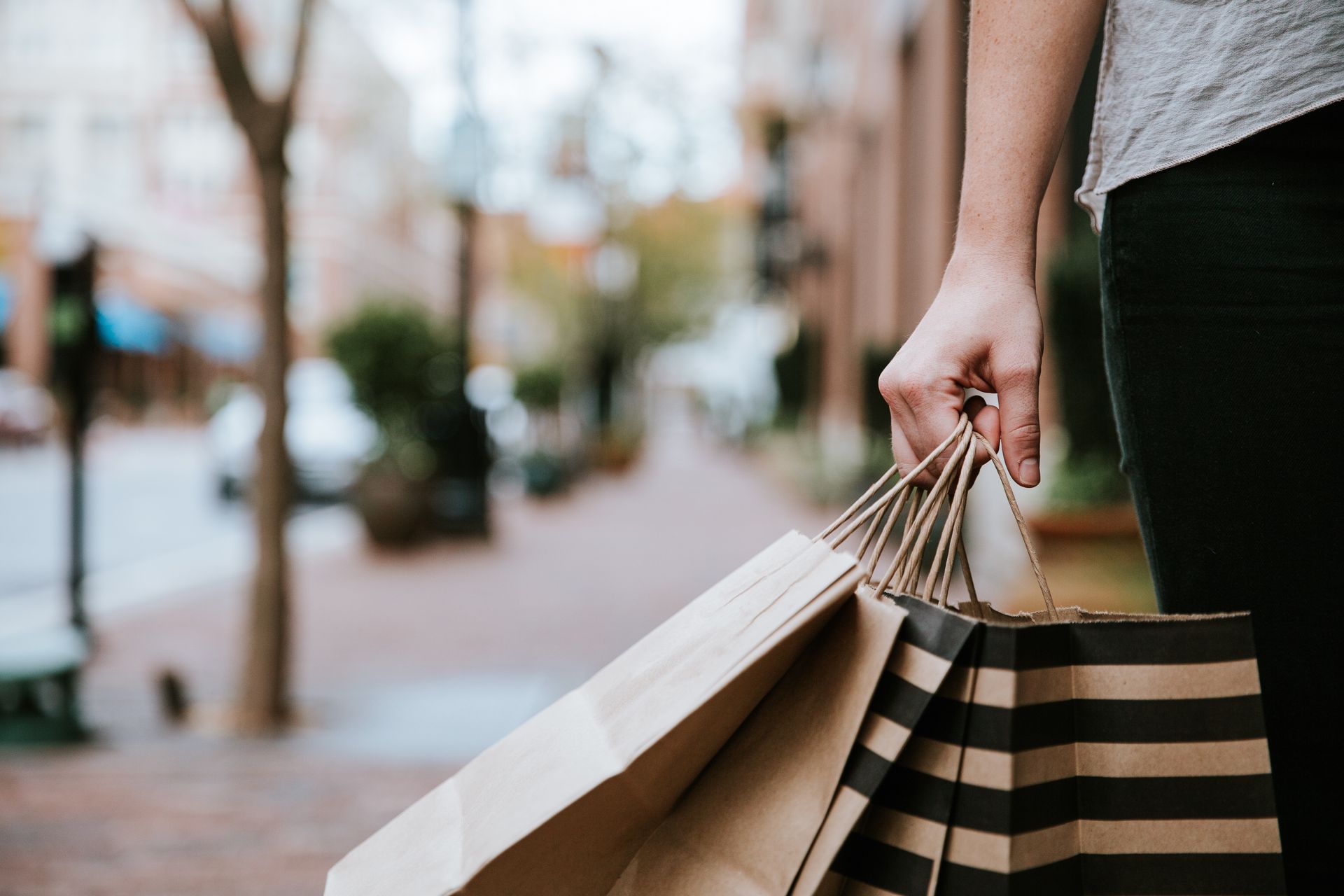 A woman is holding a bunch of shopping bags in her hand.