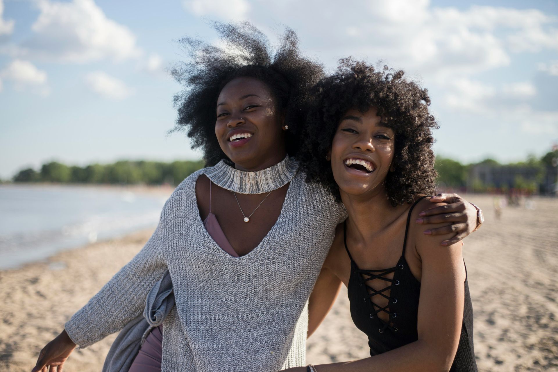 Two women are hugging each other on the beach.