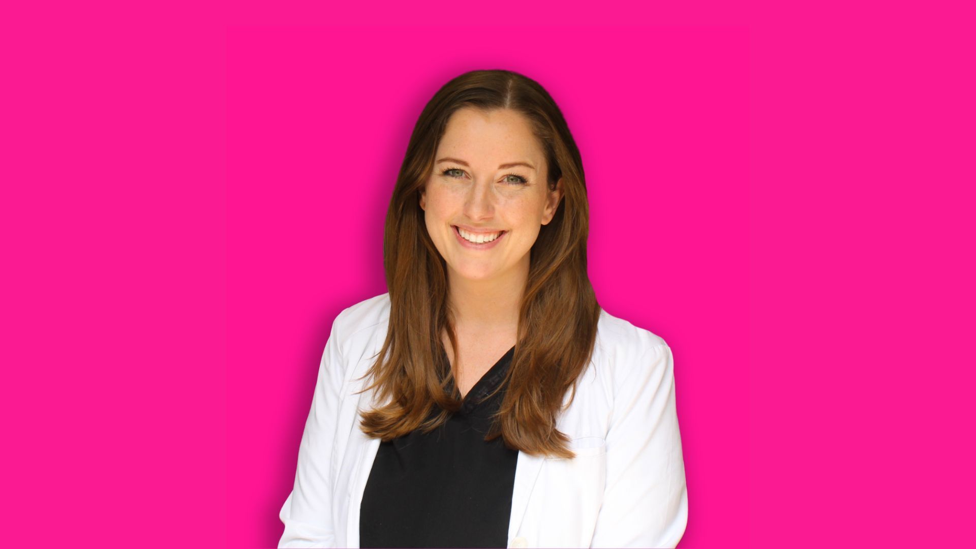 A smiling person with long brown hair, wearing a white blazer over a black top against a vibrant pink background.
