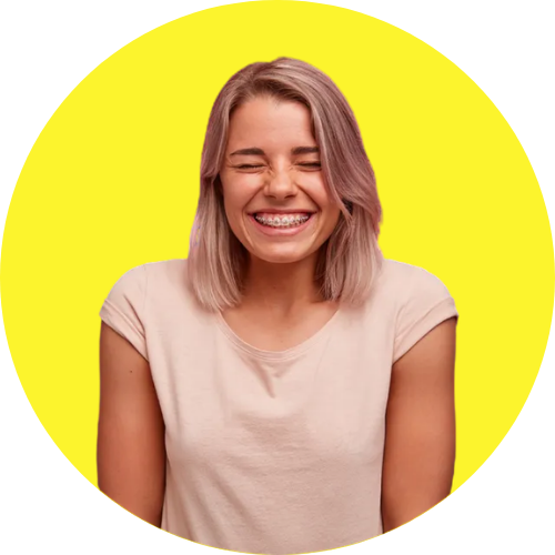 A person with shoulder-length light hair and braces smiling with eyes closed, set against a bright yellow circular background.