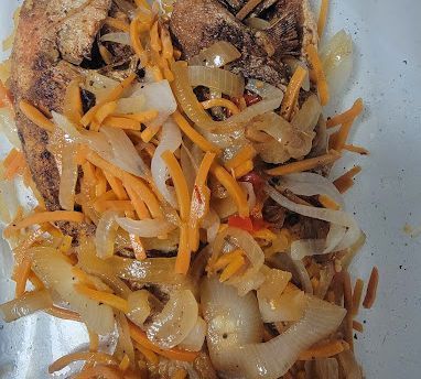 Fried fish topped with sautéed onions and carrots.