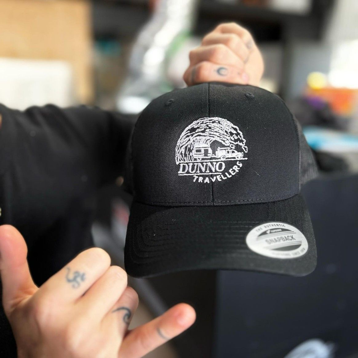 A Person is Holding a Dunno Trucker Hat in Their Hand — Fab Art in Wallabi Point, NSW