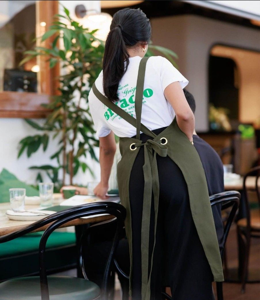 A Woman Wearing an Apron is Standing in Front of a Table — Fab Art in Wallabi Point, NSW