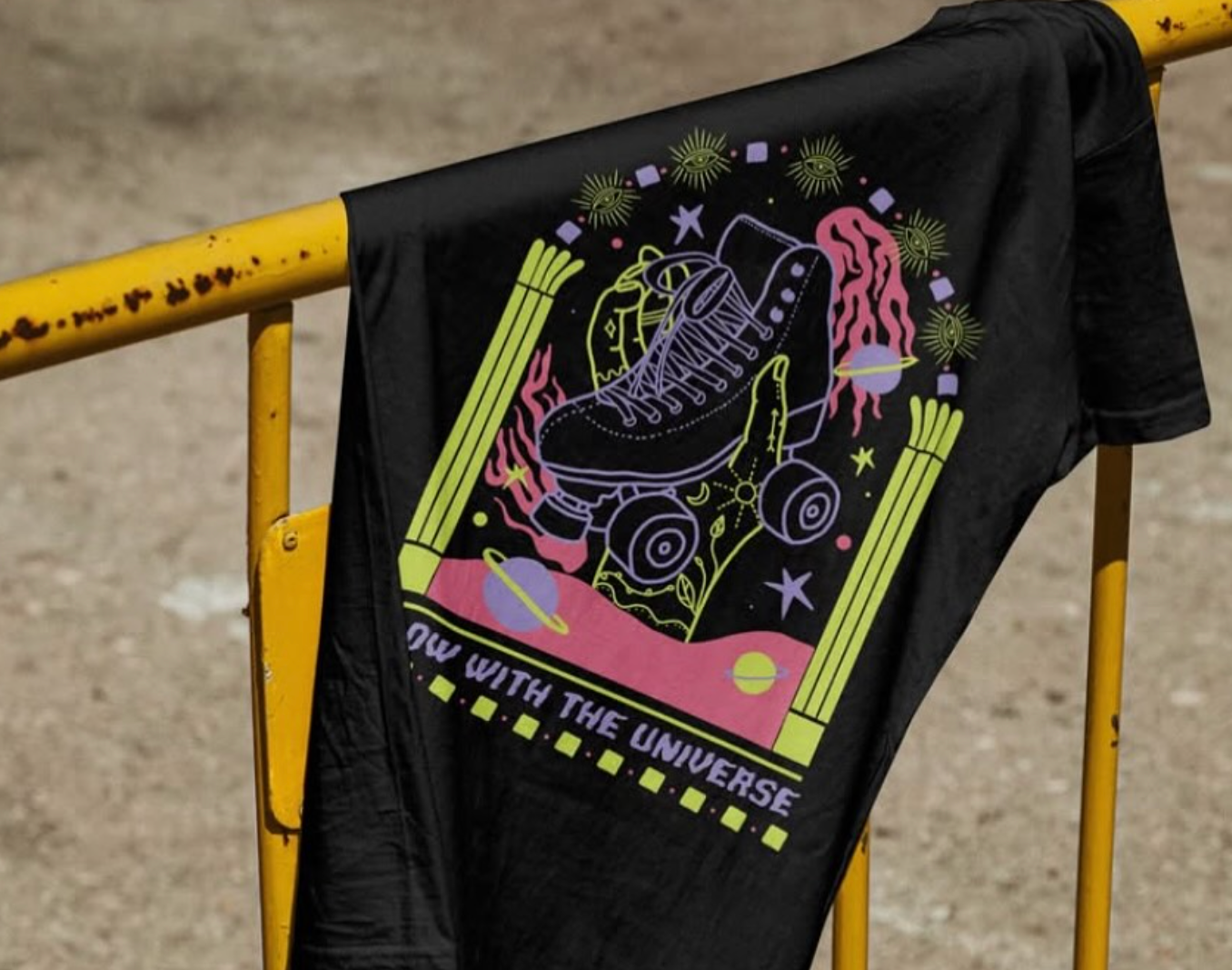 Black t-shirt with neon roller skate and space-themed design hanging on a yellow railing. — Fab Art in Wallabi Point, NSW