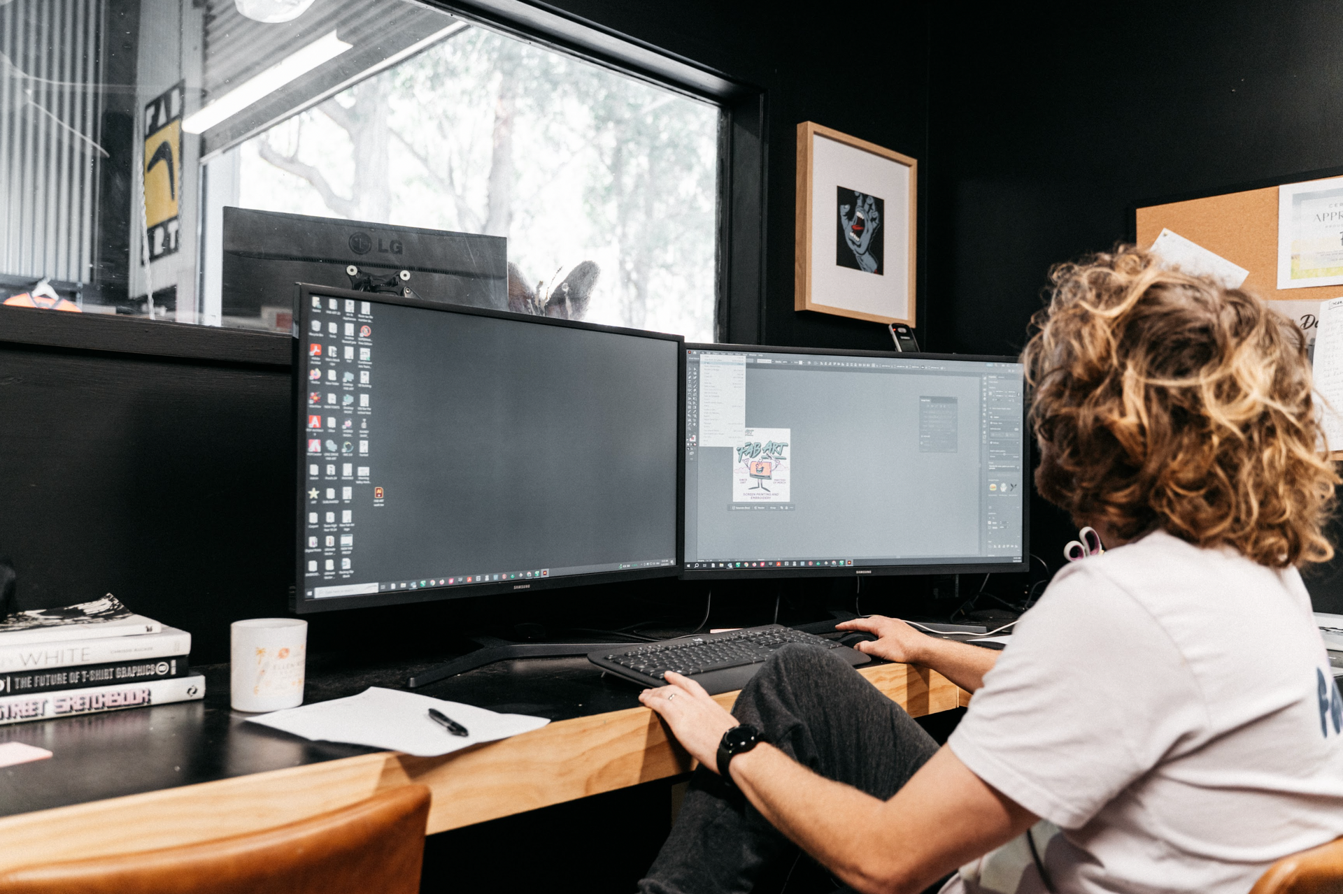 A Man Sitting In Front of A Wide Computer Screen Doing Graphic Design — Fab Art in Wallabi Point, NSW