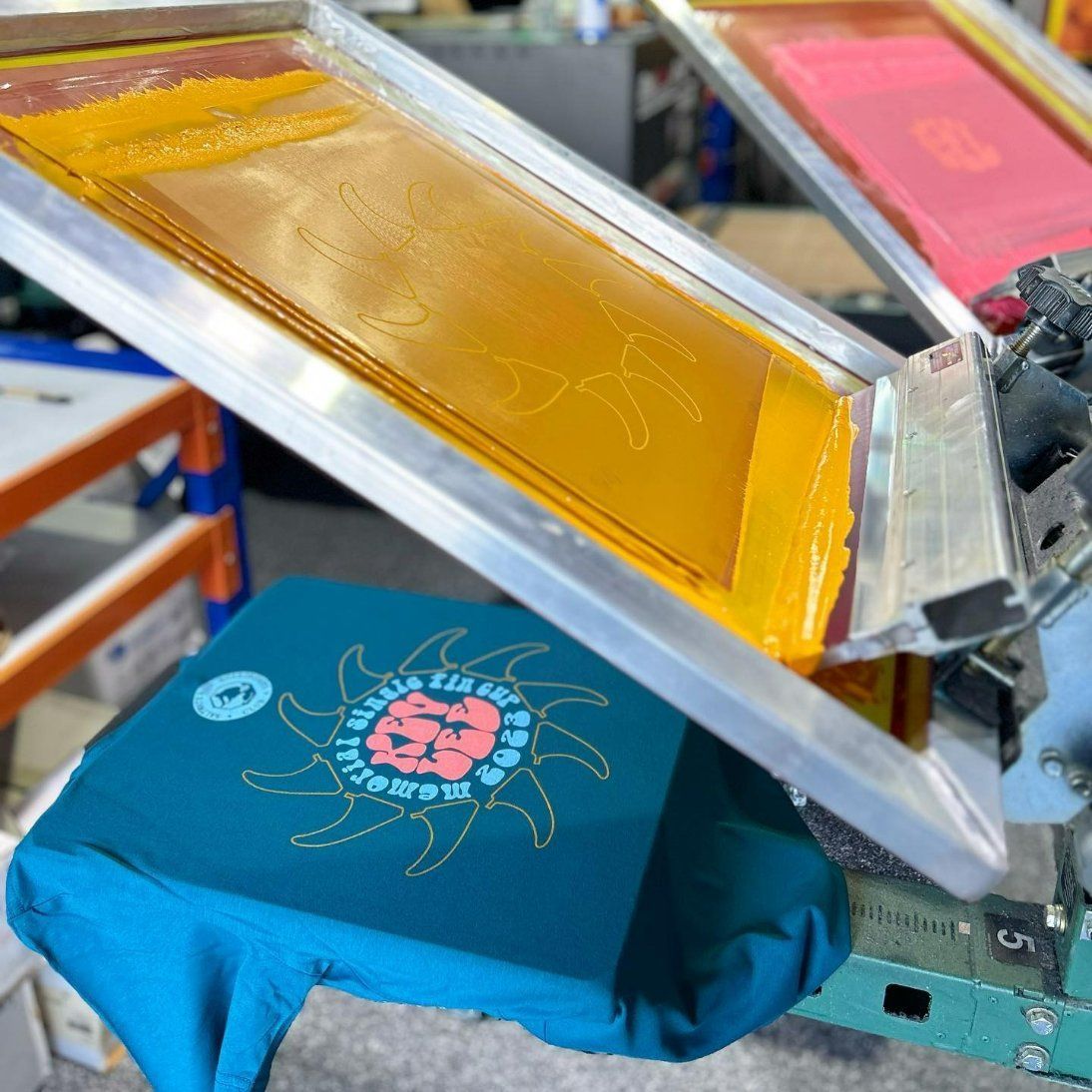 A T-Shirt Is Being Printed in A Screen Printing Machine — Fab Art in Port Macquarie, NSW