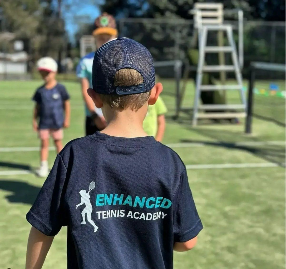 A Boy Wearing a Shirt that Says Enhanced Tennis Academy  — Fab Art in Taree, NSW