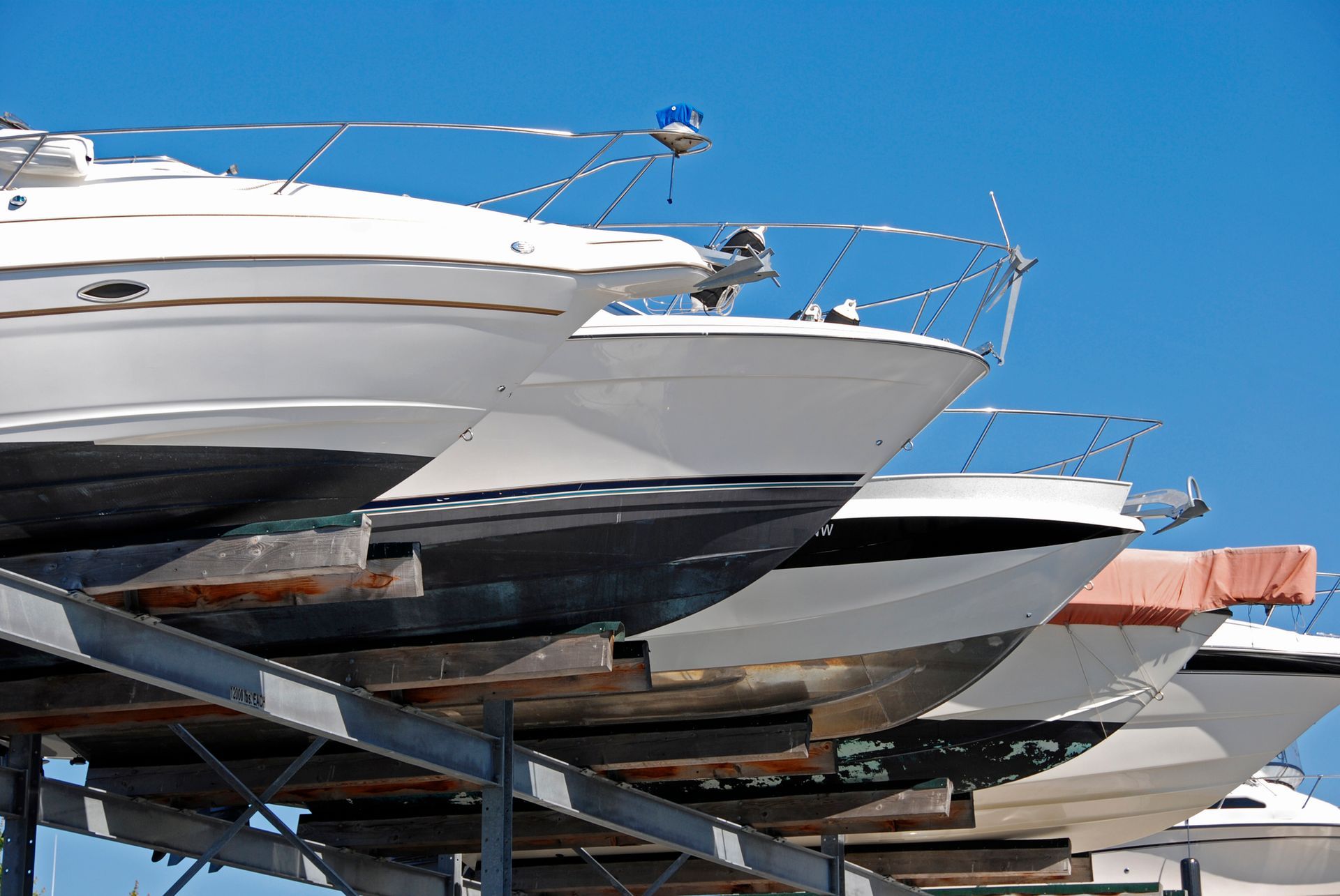 Una fila di barche sono allineate su una rastrelliera in un porto turistico.