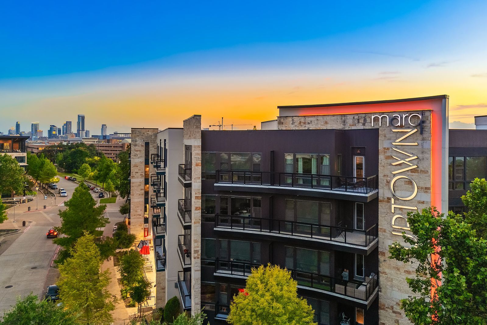 Modern apartment building at sunset with city skyline in the background