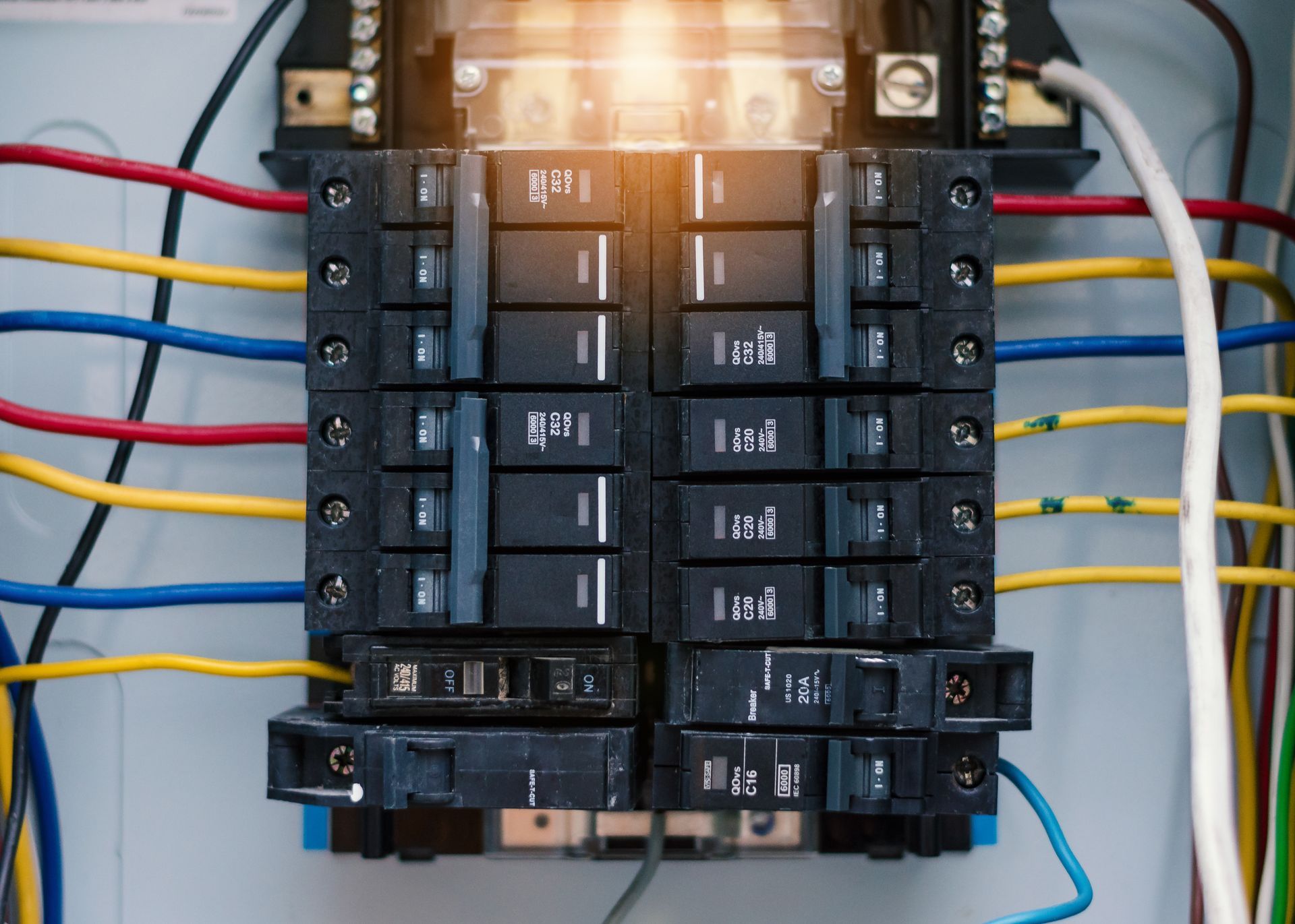 A close up of a electrical panel with lots of wires coming out of it.