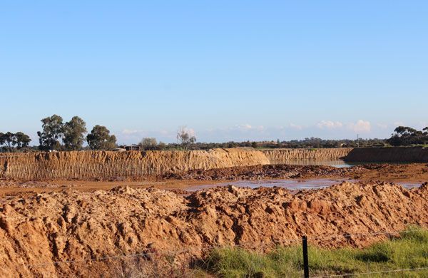 There is a large pile of dirt in the middle of a field.